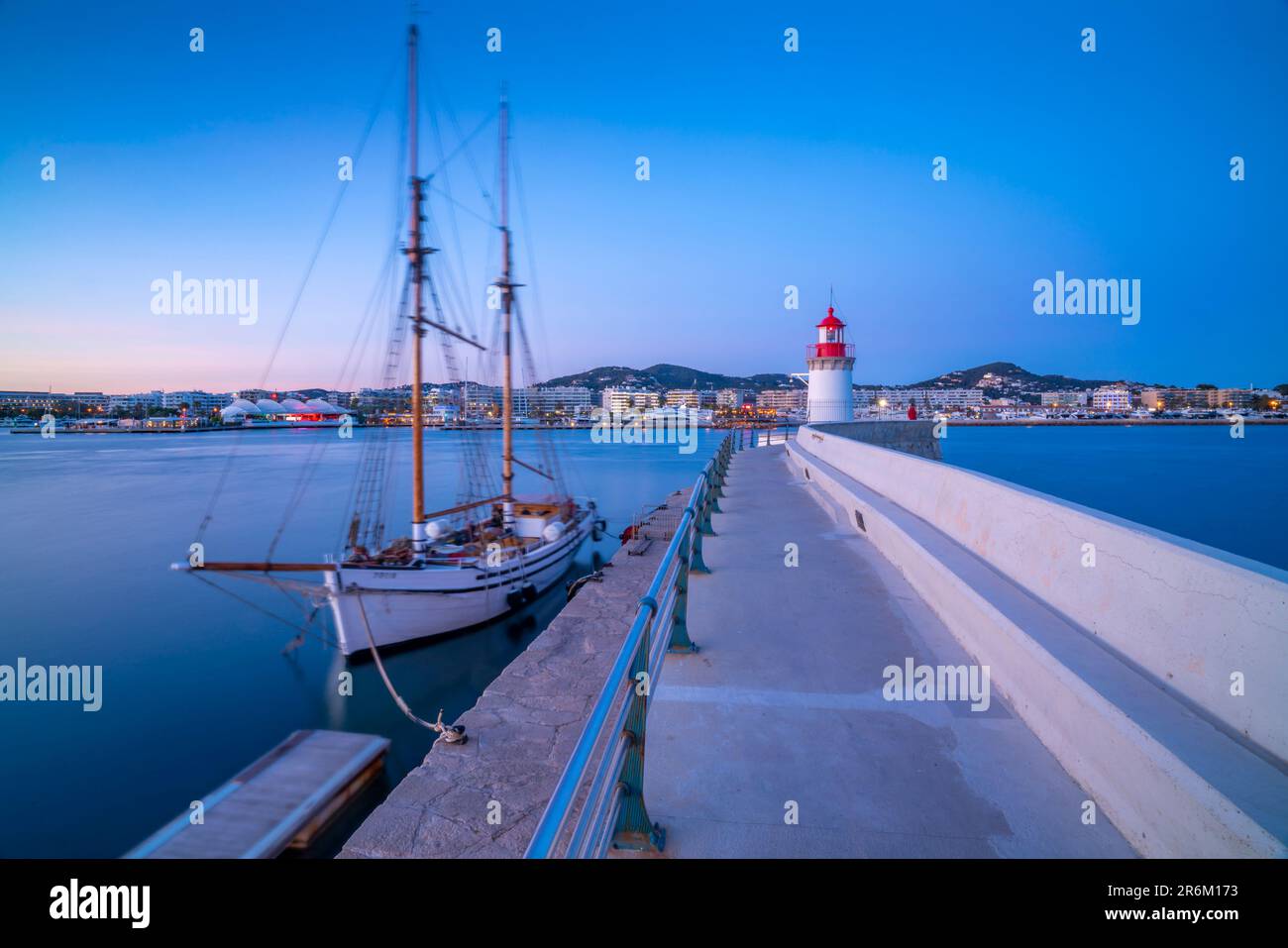 Vista del faro del porto e della nave a vela al crepuscolo, patrimonio dell'umanità dell'UNESCO, città di Ibiza, Eivissa, Isole Baleari, Spagna, Mediterraneo, Europa Foto Stock