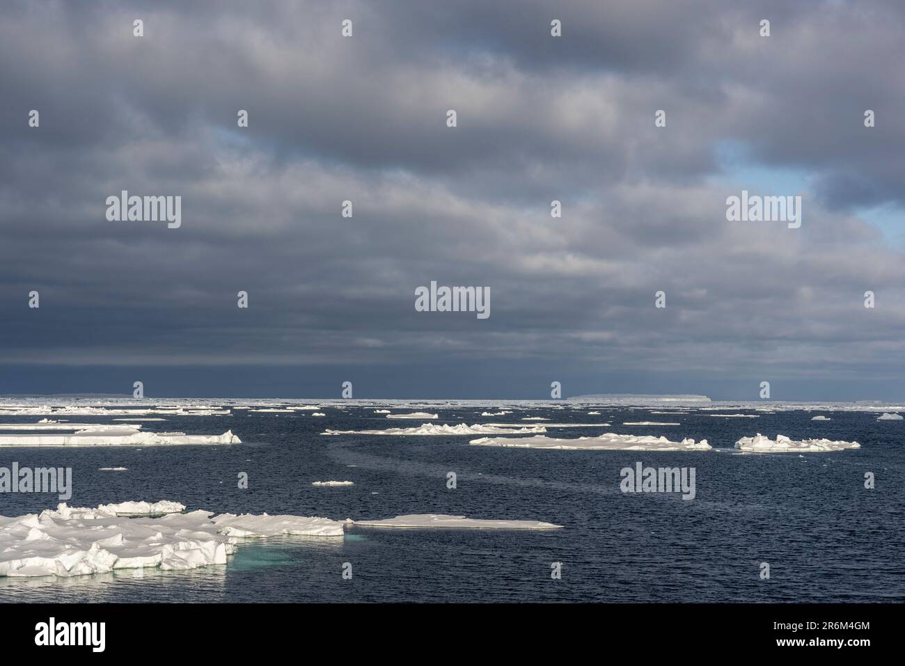 Galleggianti di ghiaccio con Iceberg tabulare in distanza, Mare di Amundsen, Antartide Foto Stock