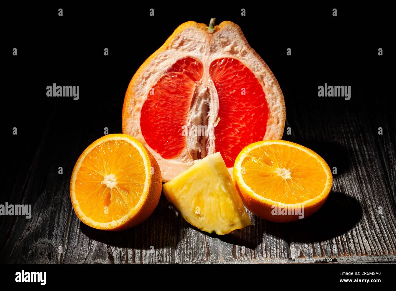 frutta tropicale a fette mescolata su sfondo di legno Foto Stock