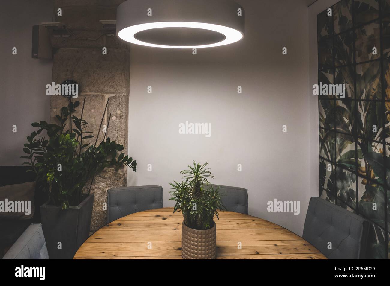 Sala da pranzo in appartamento con luce su e sedie intorno a tavola rotonda in legno Foto Stock