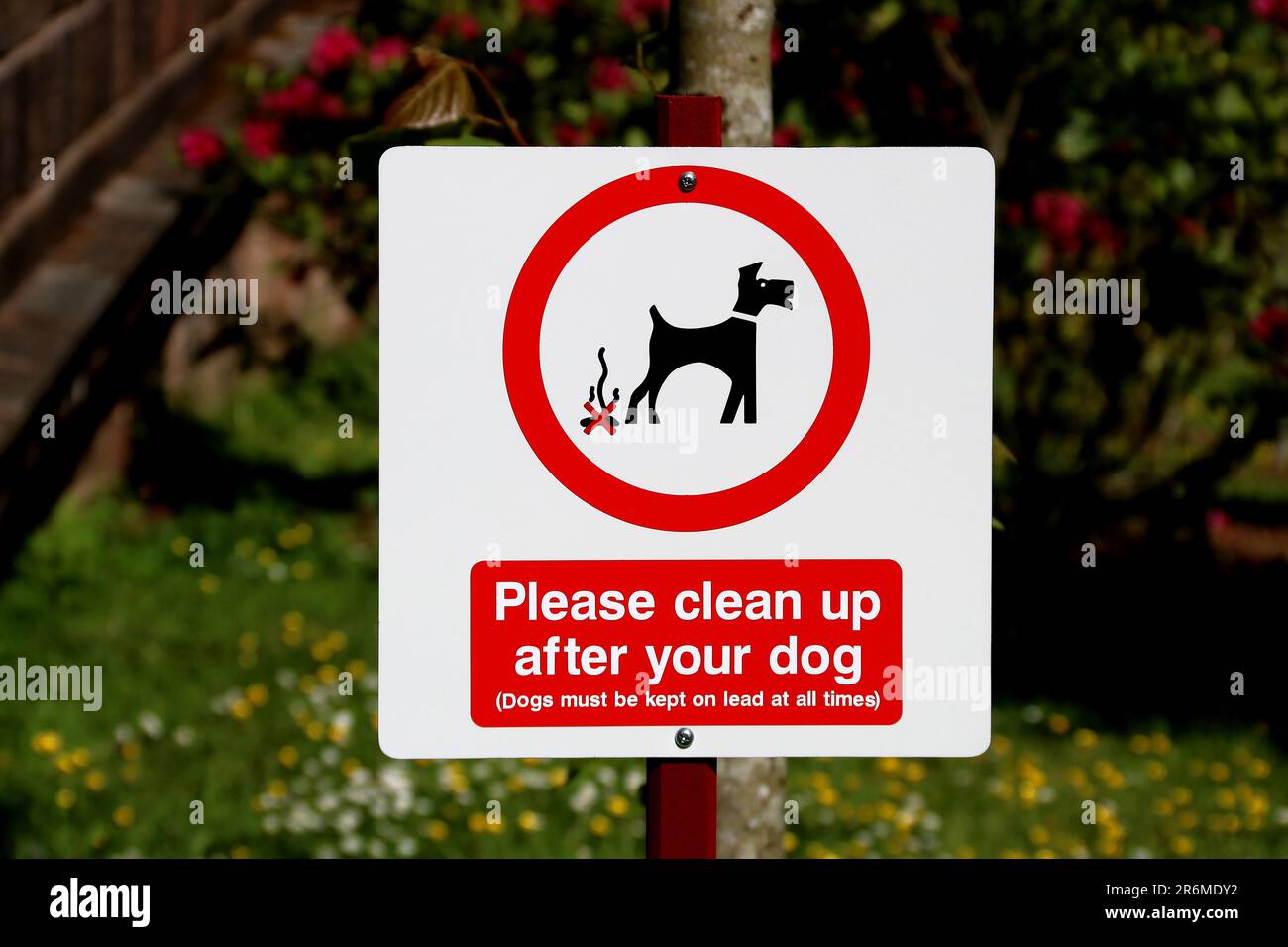 Si prega di pulire dopo il cartello con il cane situato in un parco di campagna Foto Stock