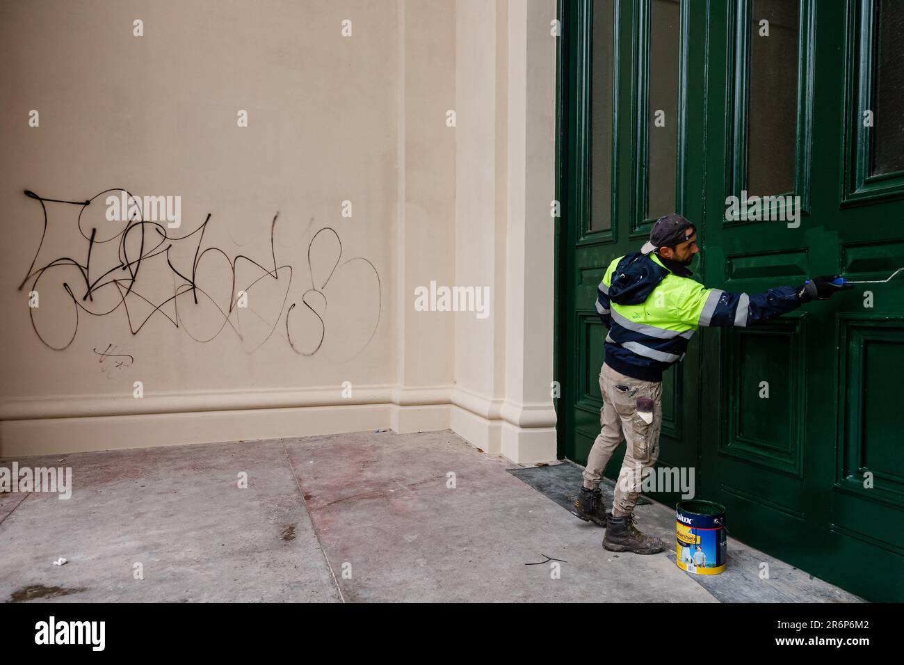 MELBOURNE, AUSTRALIA - MAGGIO 19: Dopo un restauro di $20 milioni di dollari che era stato completato nelle ultime settimane, un gruppo di circa 20 persone ha vandalizzato la facciata del Royal Exhibition Building, patrimonio dell'umanità, il sabato sera. Un operaio è visto dipingere sopra i graffiti bianchi sulle porte cerimoniali anteriori dell'entrata meridionale di Victoria durante COVID 19 il 19 maggio 2020 a Melbourne, Australia. Foto Stock