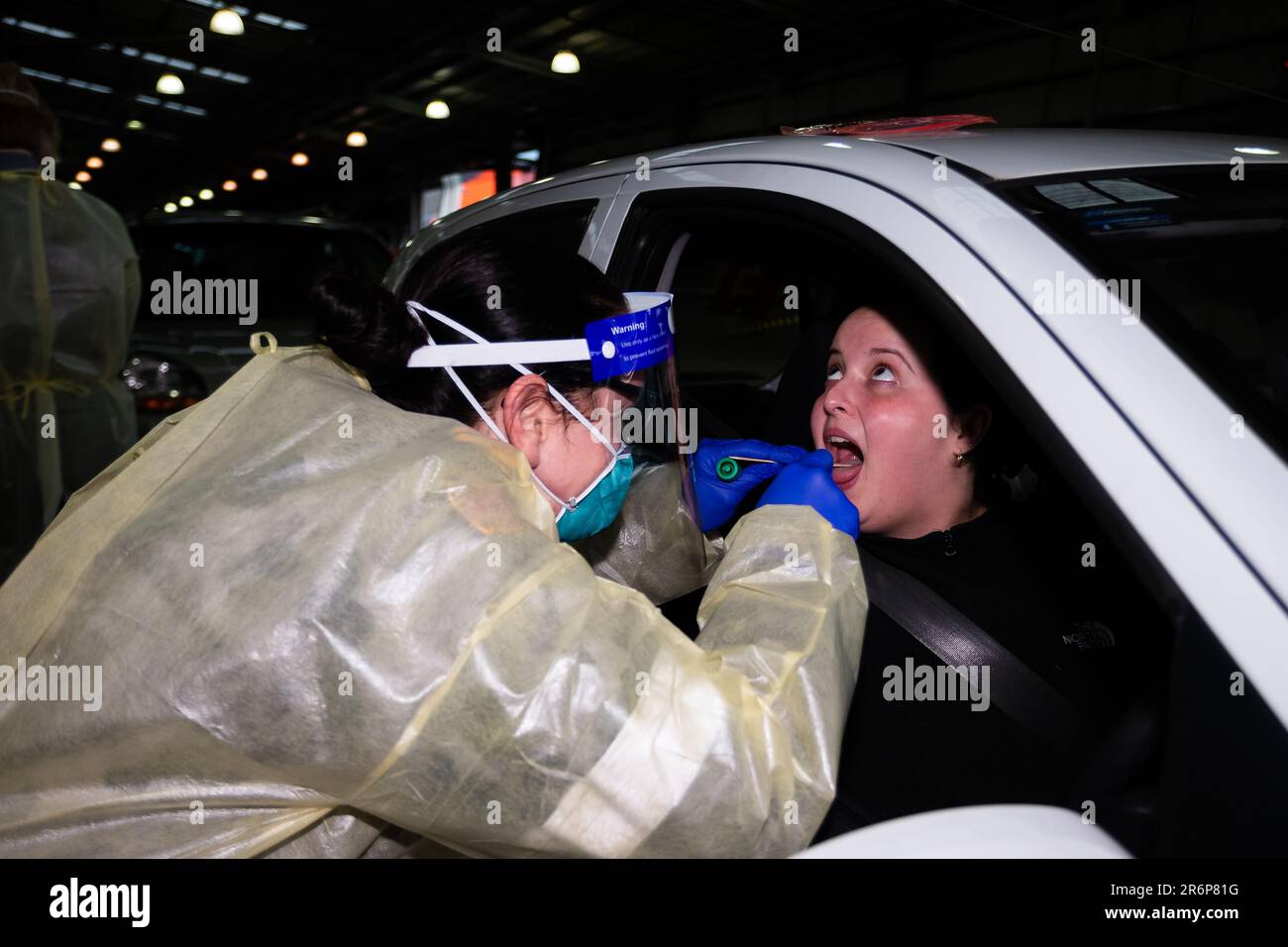 MELBOURNE, AUSTRALIA - Giugno 27: Un dottore della Marina viene visto indossare un equipaggiamento protettivo personale completo per testare una giovane donna presso il Melbourne Showgrounds Mobile Testing Site mentre l'esercito viene chiamato ad assistere nei siti di test di Melbourne durante il COVID 19 del 27 Giugno 2020 a Melbourne, Australia. Nell'ambito di un preoccupante aumento dei casi positivi al test di Coronavirus a Victoria, che sta suscitando timori di una seconda ondata del Premier di Stato, Daniel Andrews ha annunciato la scorsa settimana che un blitz di test mirato sarebbe stato lanciato ieri (26 giugno) in dieci sobborghi mirati a zero in trasmissione comunitaria. Foto Stock