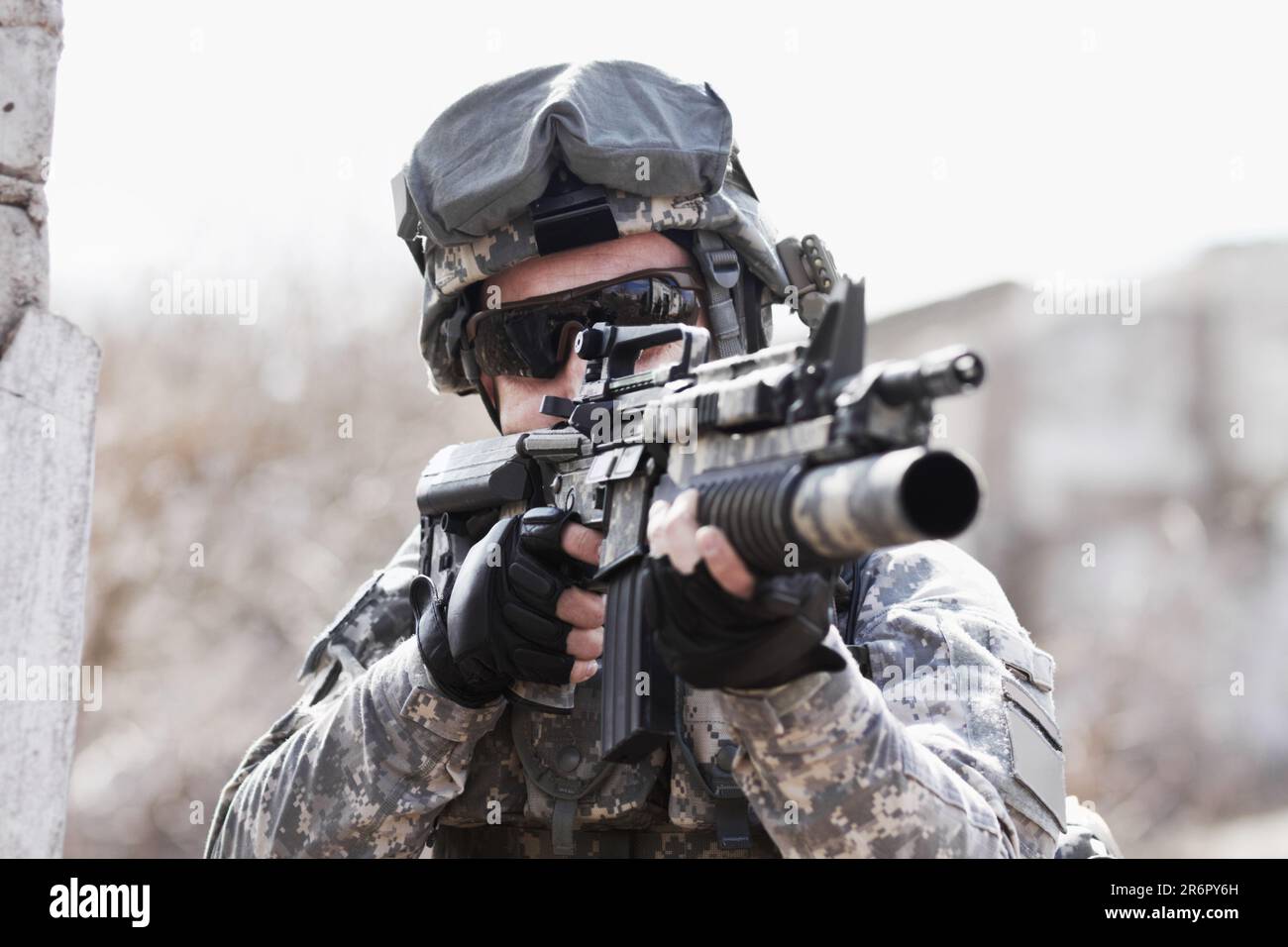 Guerra, addestramento e uomo con la pistola nell'esercito per un obiettivo, servizio o una missione. Militare, eroe e un soldato con un fucile sul campo di battaglia per Foto Stock