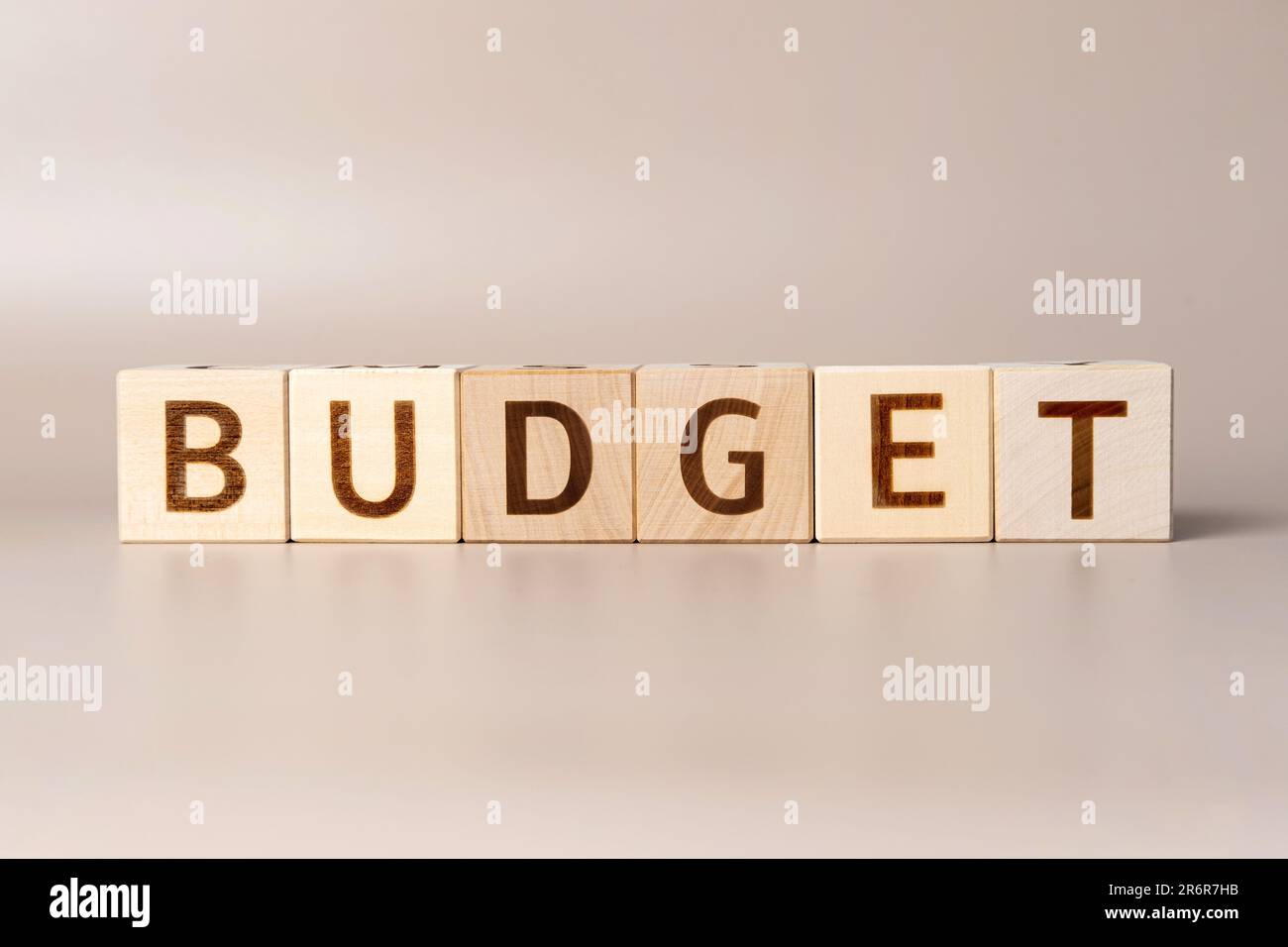 La parola BUDGET su cubi di legno su uno sfondo beige neutro studio. Copia spazio. Scritto. Le parole di testo contano. Foto concettuale. Simbolo di pianificazione del budget Foto Stock