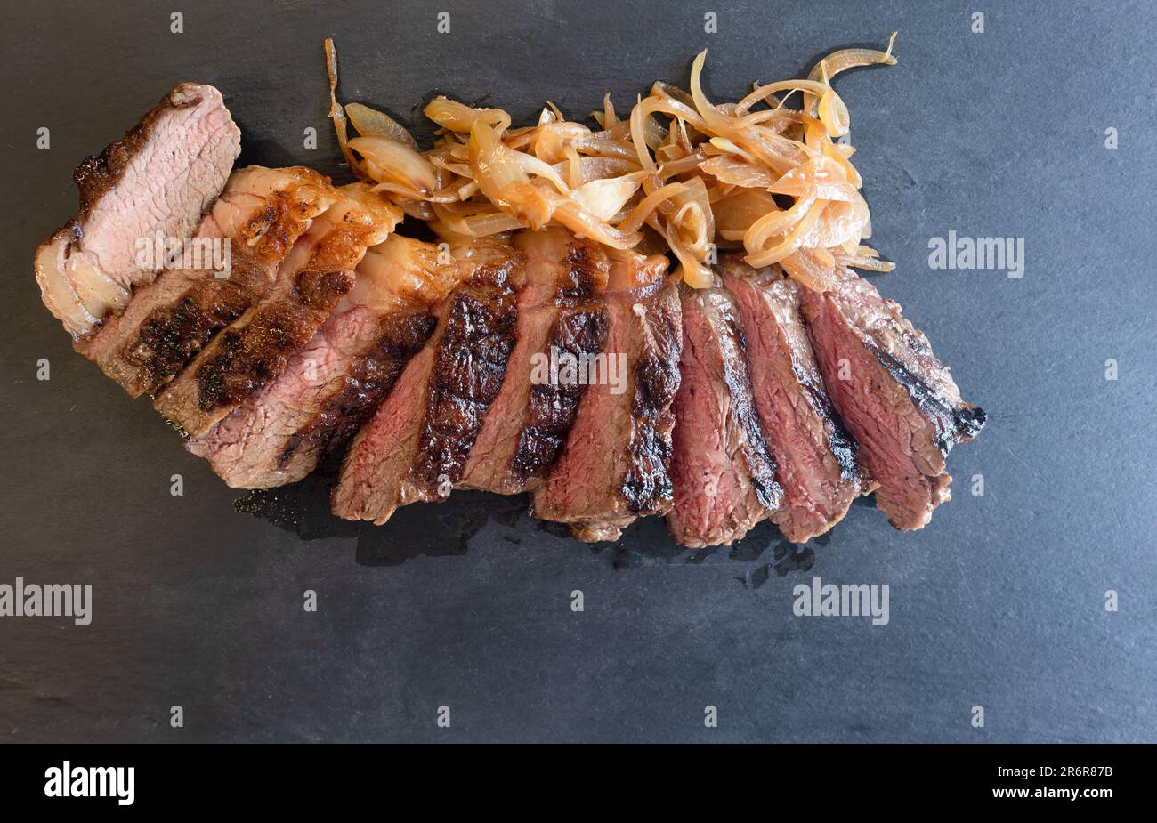 Goditi un capolavoro culinario con la nostra succulenta bistecca di controfiletto, tagliata alla perfezione. Servito insieme a una generosa porzione di caramellato Foto Stock