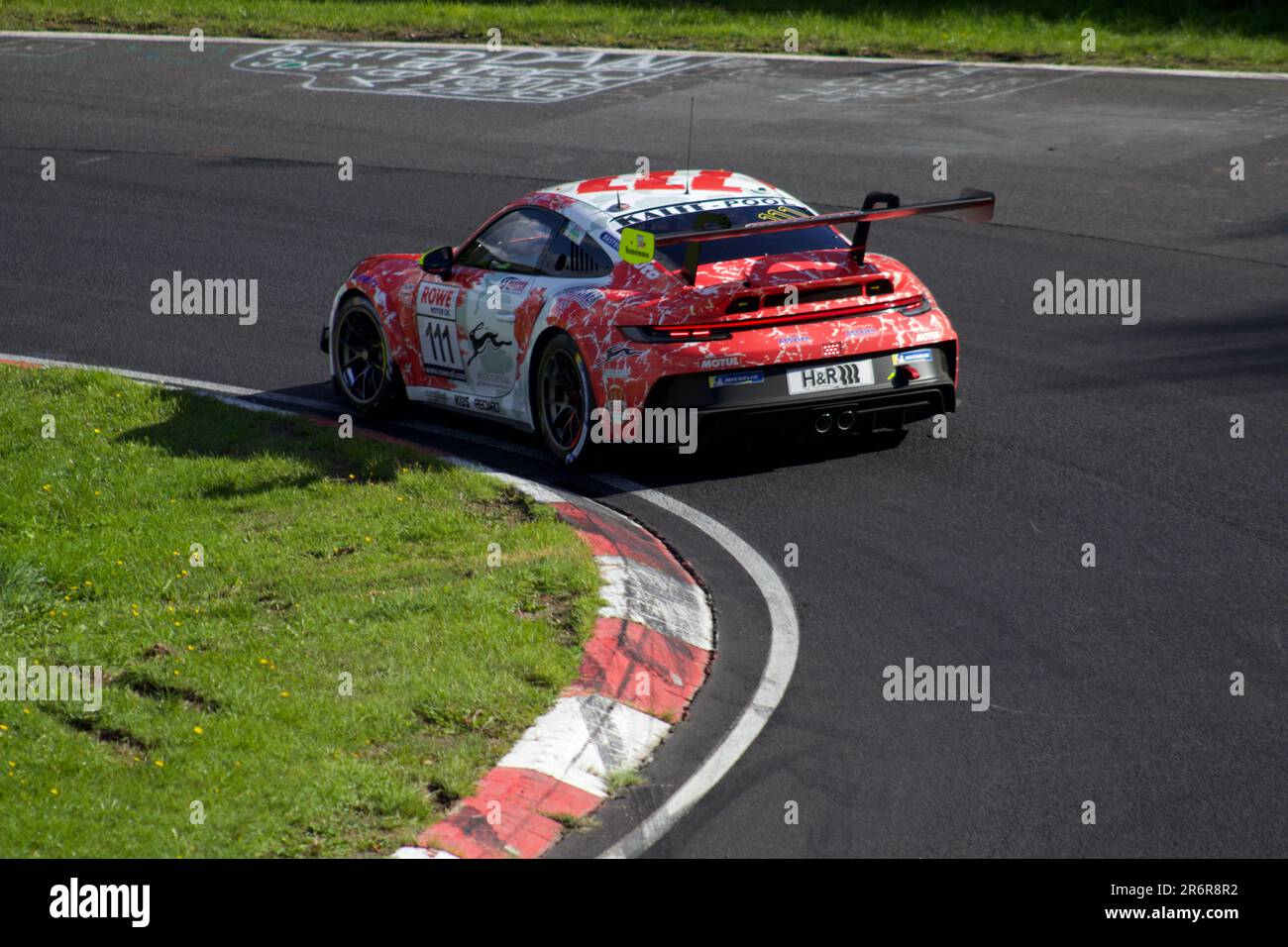 Un'auto da corsa arancione che guida su una pista, perfetta per qualsiasi sport motoristico o grafica correlata alle corse Foto Stock