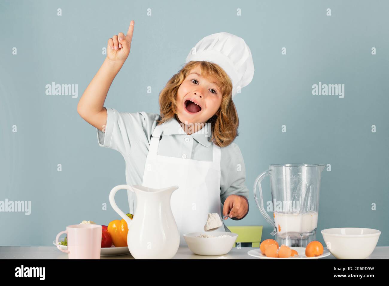 Bambino che indossa uniforme cucina e cappello chef preparare il cibo con  farina in cucina, ritratto studio. Cucina, cucina e cibo per bambini Foto  stock - Alamy