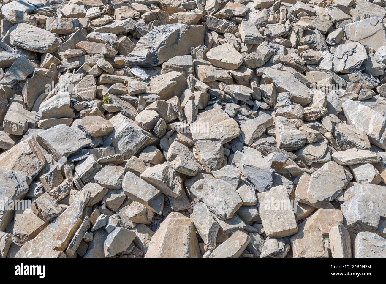 Campo di pietra di hardcore rotta in luce solare brillante. Essendo usato per correggere la strada fatiscente della fattoria di paese. Pietra più grande circa 25cm. Caduta su terreno roccioso Foto Stock