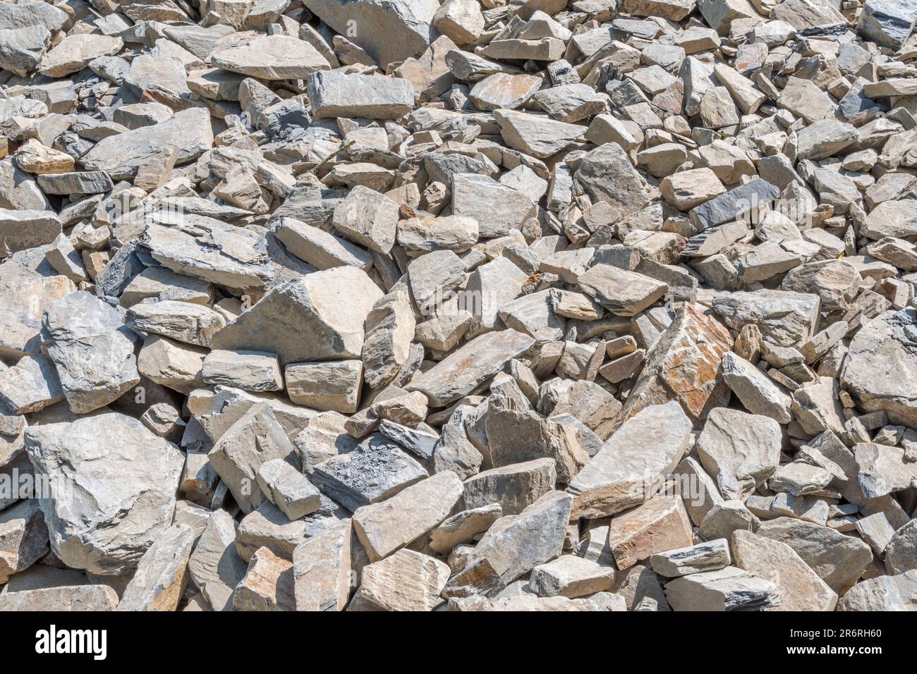 Campo di pietra di hardcore rotta in luce solare brillante. Essendo usato per correggere la strada fatiscente della fattoria di paese. Pietra più grande circa 25cm. Caduta su terreno roccioso Foto Stock
