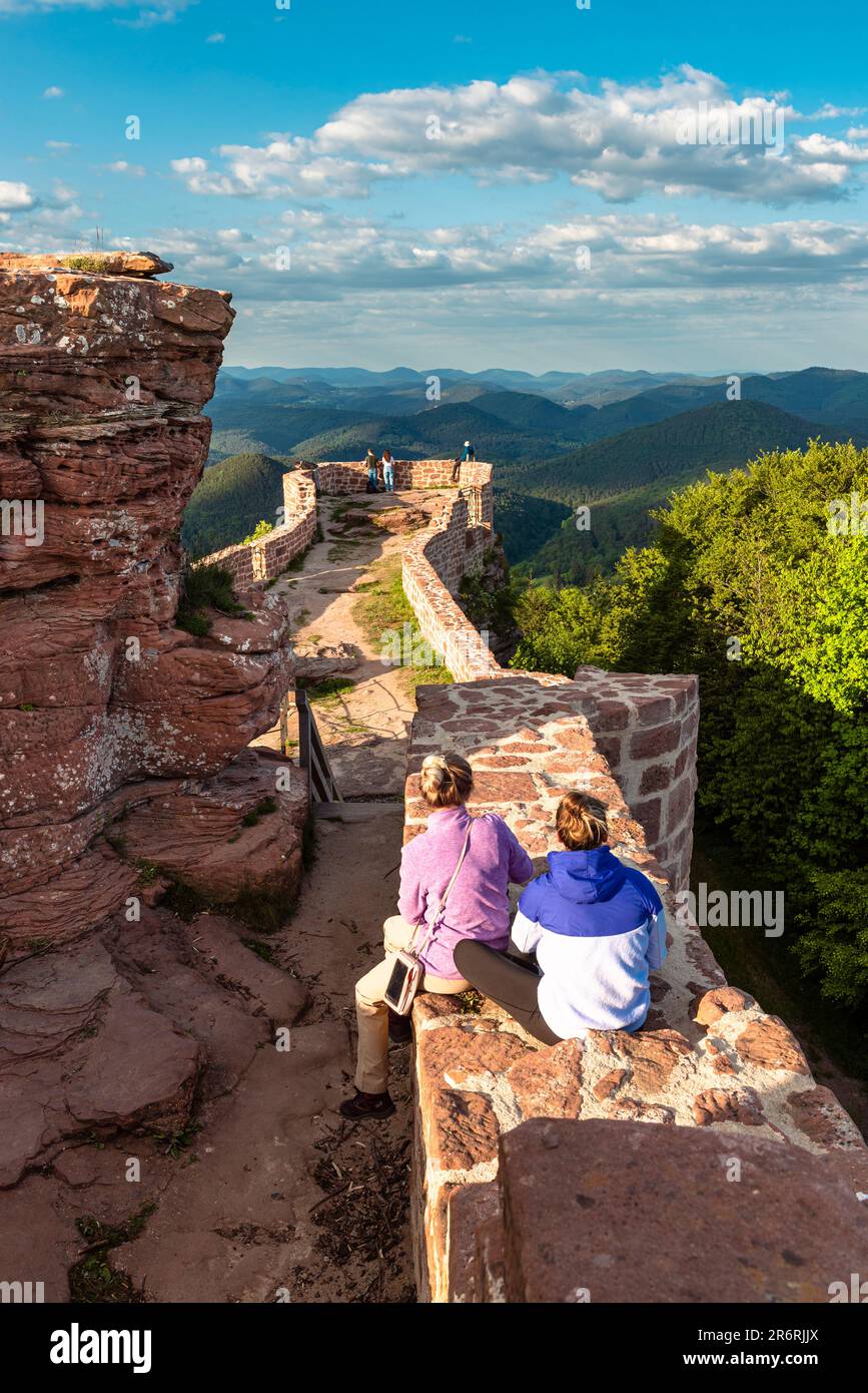 Due donne sedute sulle rovine del Castello di Wegelnburg e che guardano il panorama dei Monti Palatinati, Renania-Palatinato, Germania Foto Stock