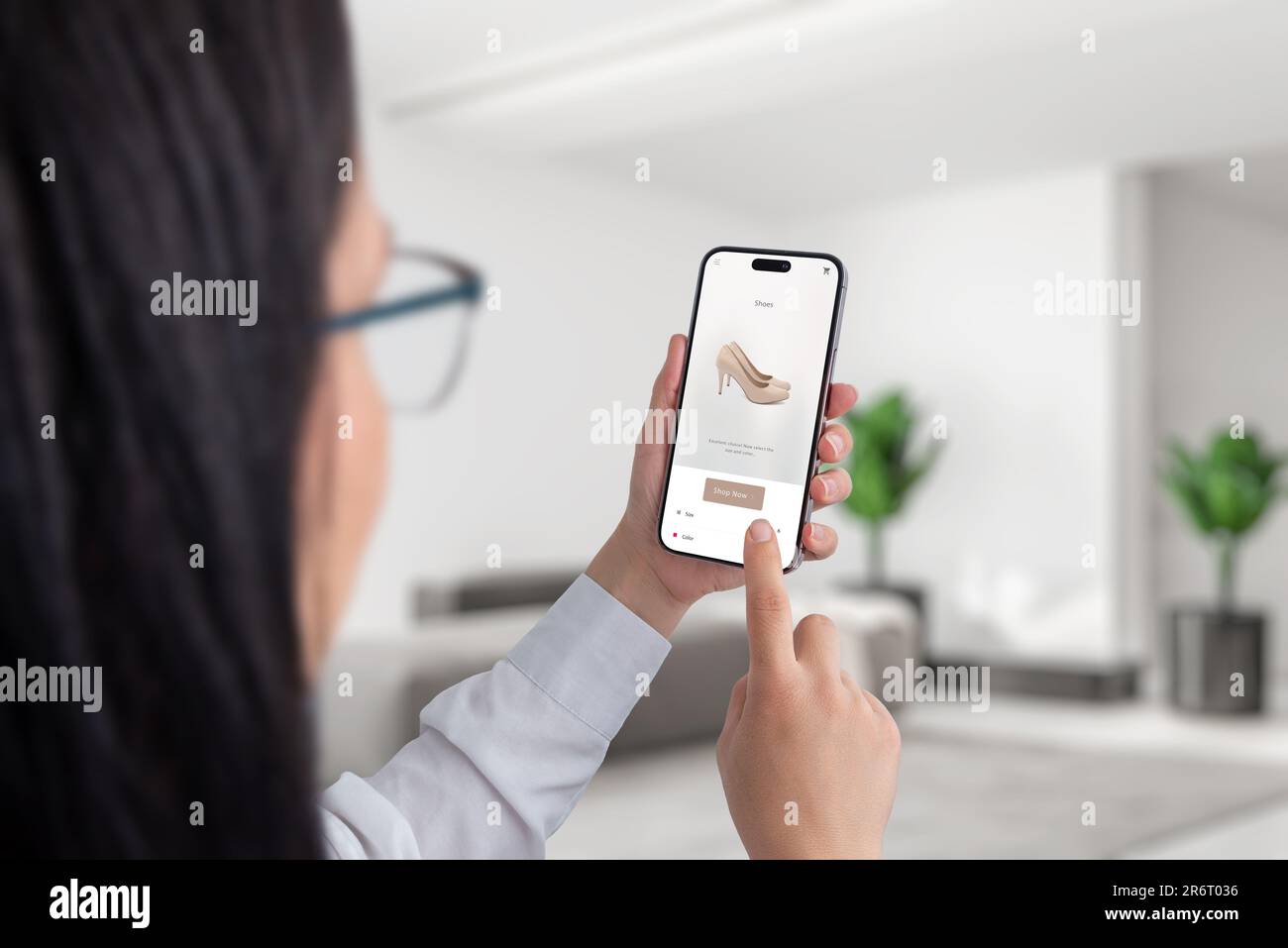 Donna che acquista online beige scarpe da donna con tacchi su ecommerce pagina web con smartphone Foto Stock