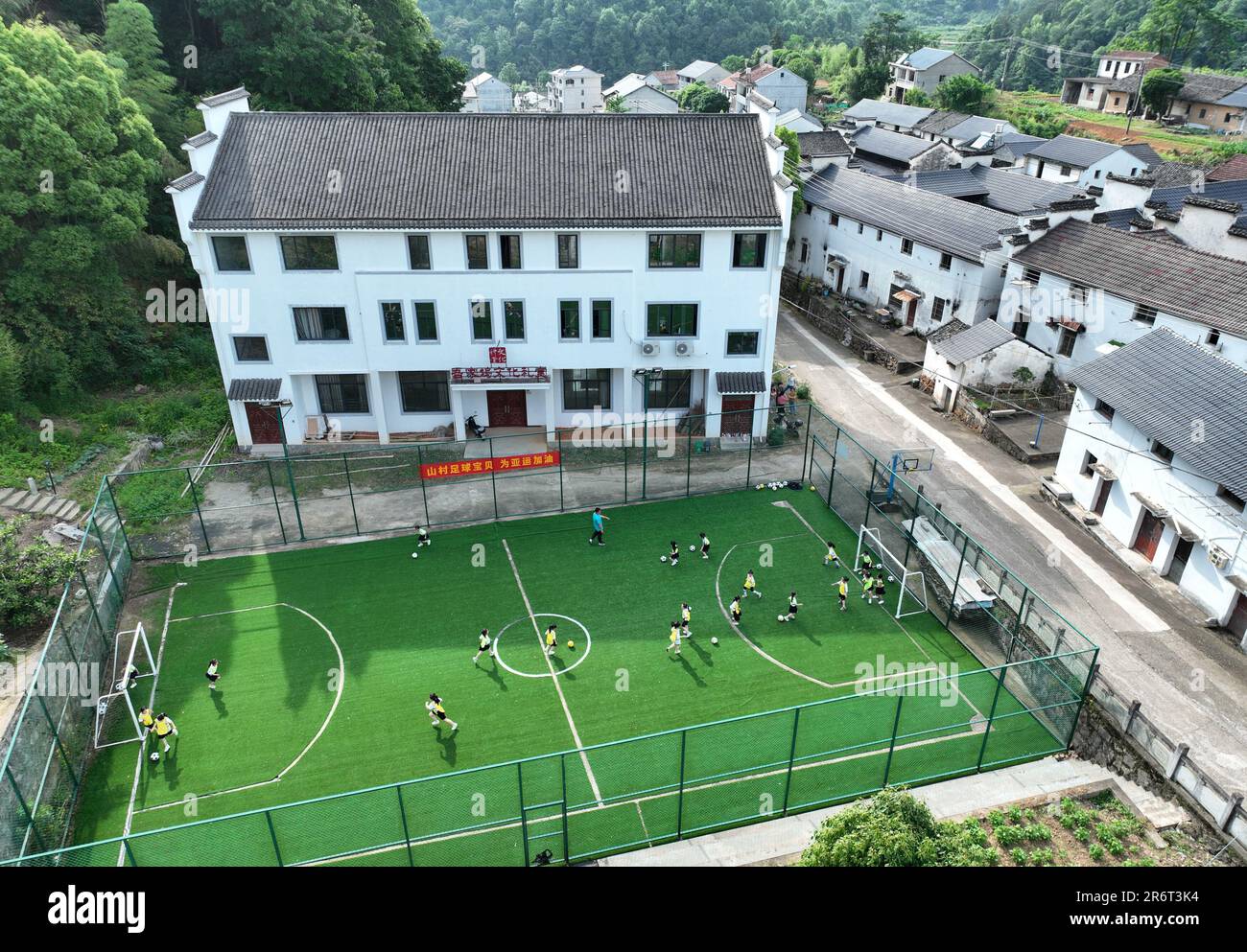 (230611) -- HANGZHOU, 11 giugno 2023 (Xinhua) -- gli studenti della scuola primaria giocano a calcio a Lipu Town, Zhuji City, nella provincia di Zhejiang della Cina orientale, 25 maggio 2023. Dal 2003, Zhejiang, situato nel delta del fiume Yangtze, ha implementato un programma di revival verde rurale per la revisione dell'ambiente di vita dei villaggi, che è stato assegnato il programma delle Nazioni Unite per l'ambiente (UNEP) Champions of the Earth Award nel settembre 2018. Per vent'anni, il programma ha creato migliaia di splendidi villaggi, e ha cambiato radicalmente il volto della campagna della provincia. (Xinhua/Weng Xinyang) Foto Stock
