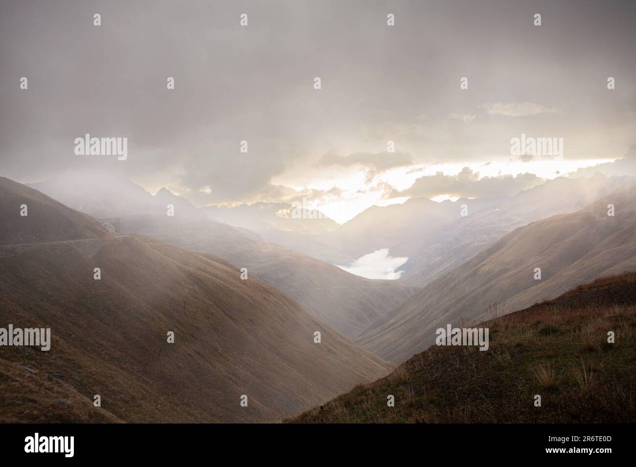 Mistico paesaggio montano in Svizzera, adornato di nebbia e cielo nuvoloso, che crea un'atmosfera eterea e accattivante Foto Stock