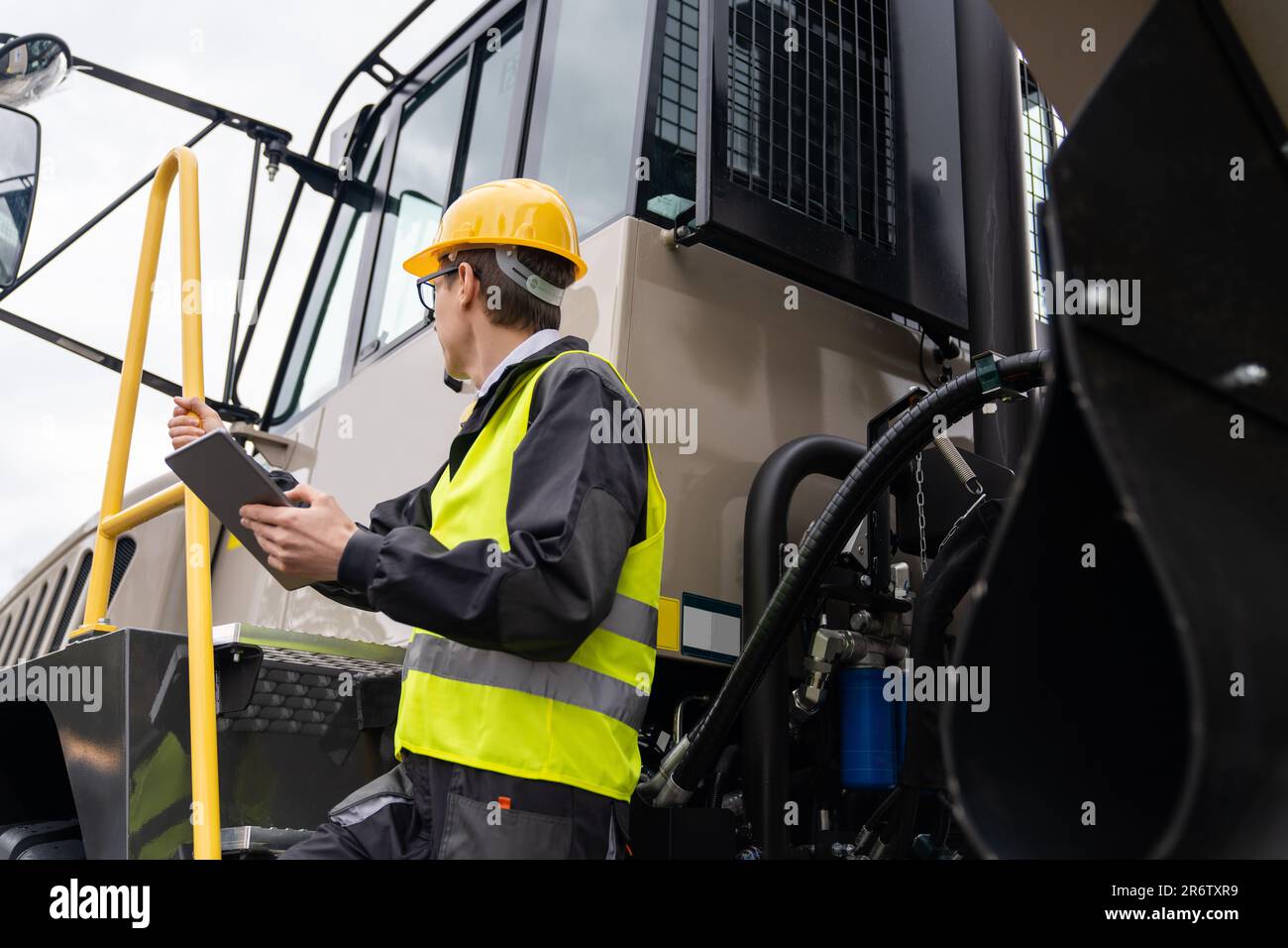 Ingegnere con computer tablet è in piedi sulle scale per la cabina di un camion Foto Stock