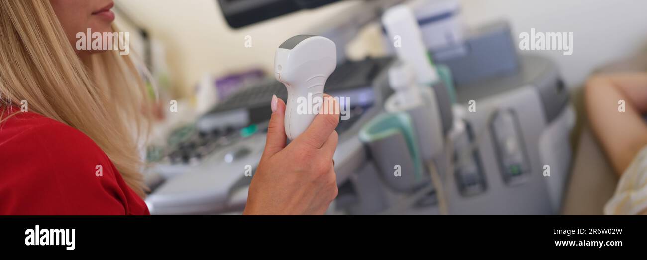 Medico donna che tiene il trasduttore a ultrasuoni e che esamina la paziente di sesso femminile Foto Stock