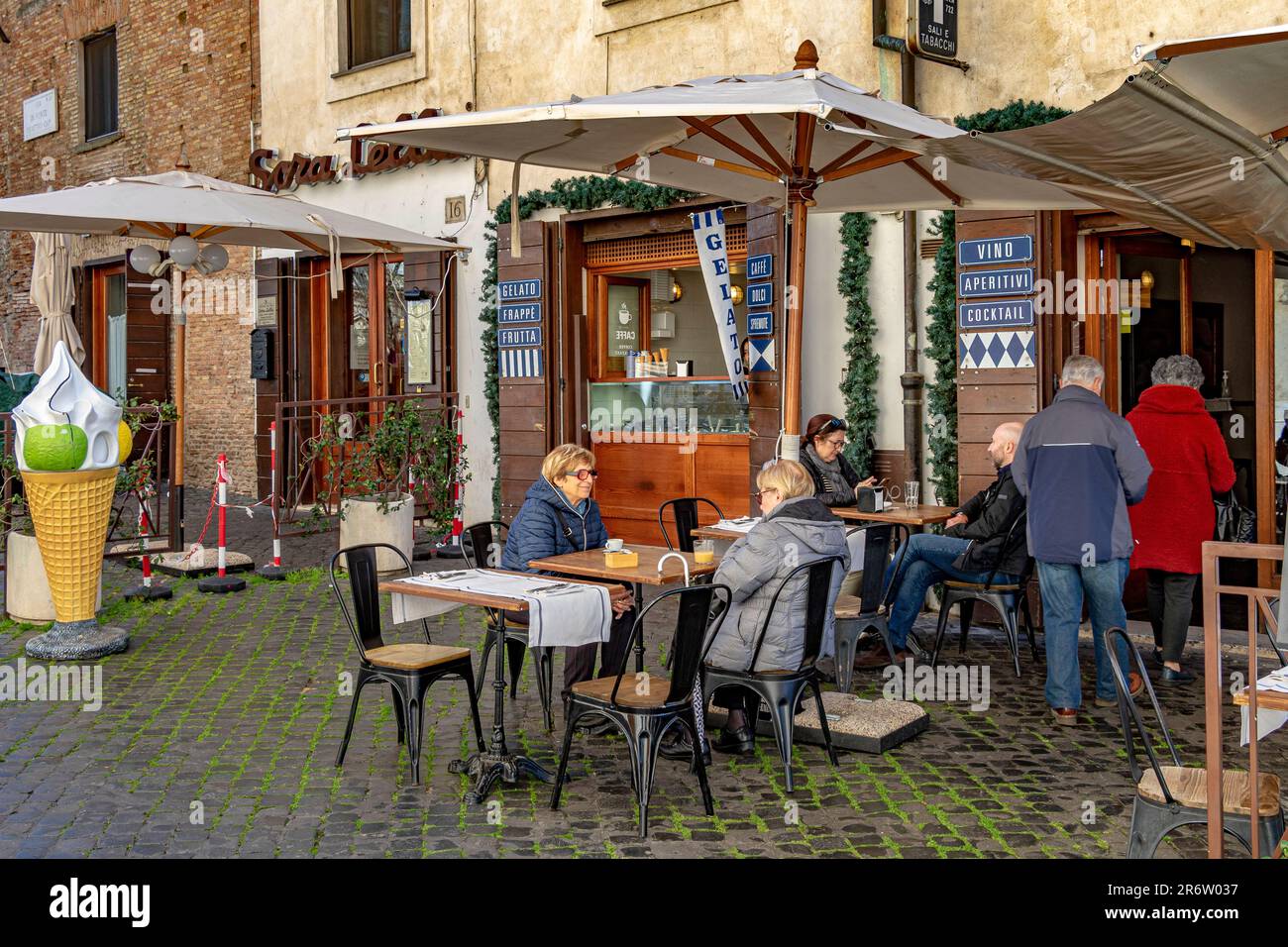 Persone sedute fuori Tiberino Ristorante, un piccolo ristorante italiano a conduzione familiare sull'Isola Tiberina, Roma, Italia Foto Stock