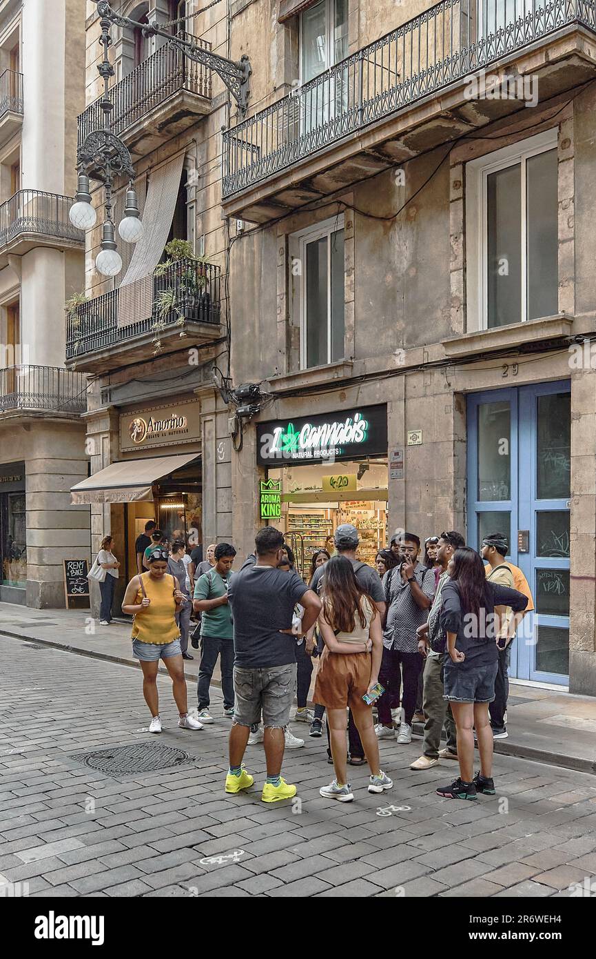 Barcellona - 11 giugno 2023: Esplorare la cultura della cannabis: Un gruppo diversificato di persone di fronte a un negozio di cannabis nel cuore di Barcellona, Spagna Foto Stock