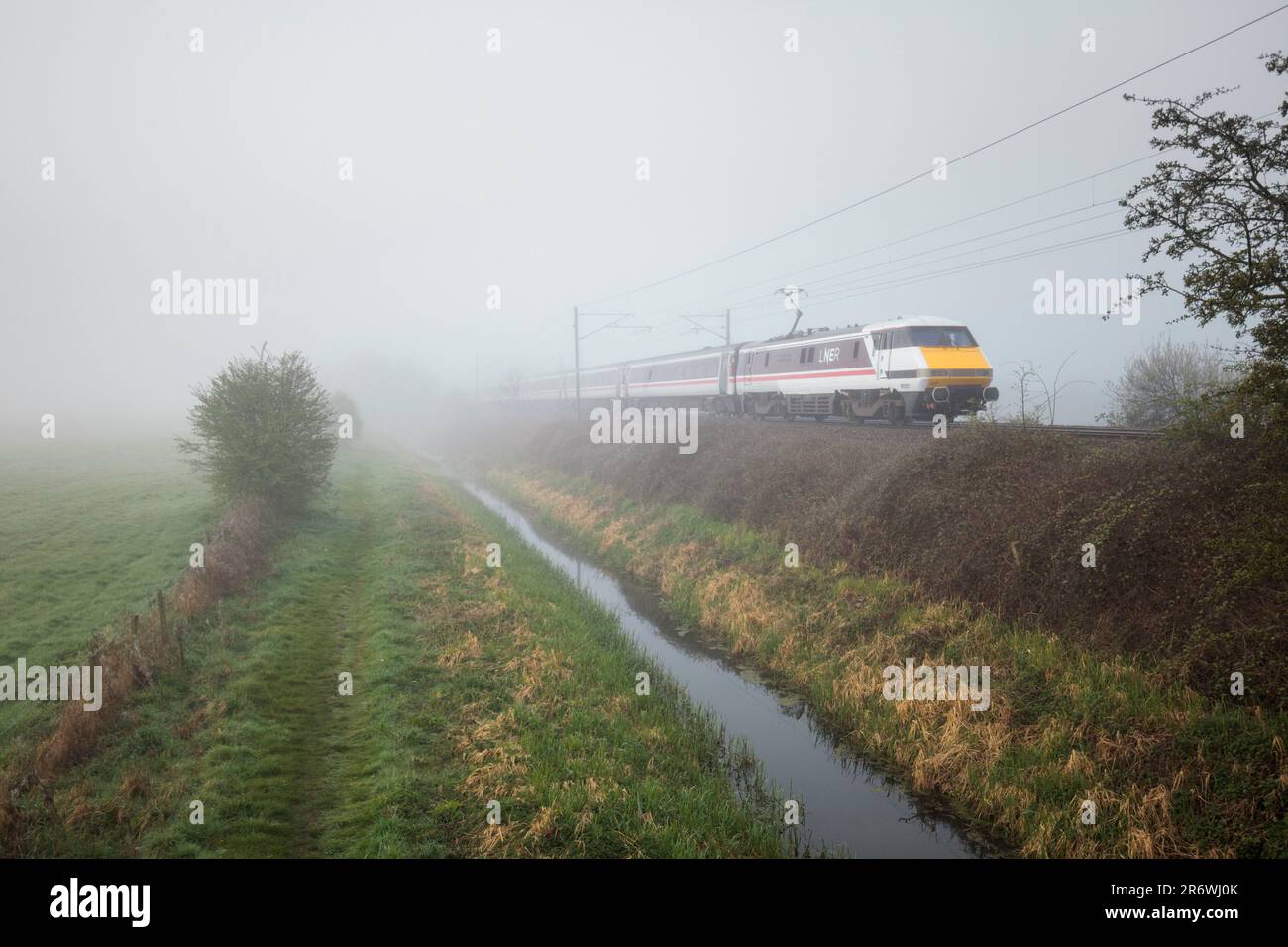 Treno LNER Intercity 225 e locomotiva elettrica classe 91 91107 sulla linea principale della costa orientale nella nebbia Foto Stock