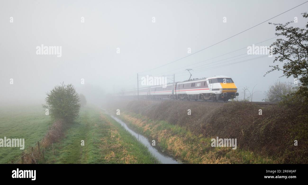 Treno LNER Intercity 225 e locomotiva elettrica classe 91 91107 sulla linea principale della costa orientale nella nebbia Foto Stock