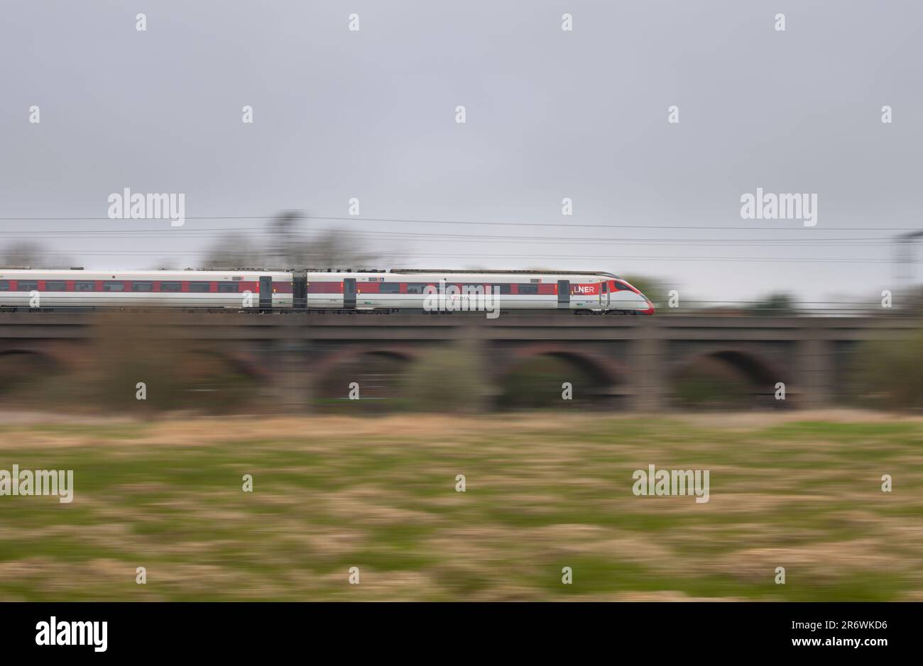 LNER classe 801 treno elettrico Azuma che accelera lungo la linea principale della costa orientale con sfocatura del movimento che attraversa il viadotto di Bawtry Foto Stock