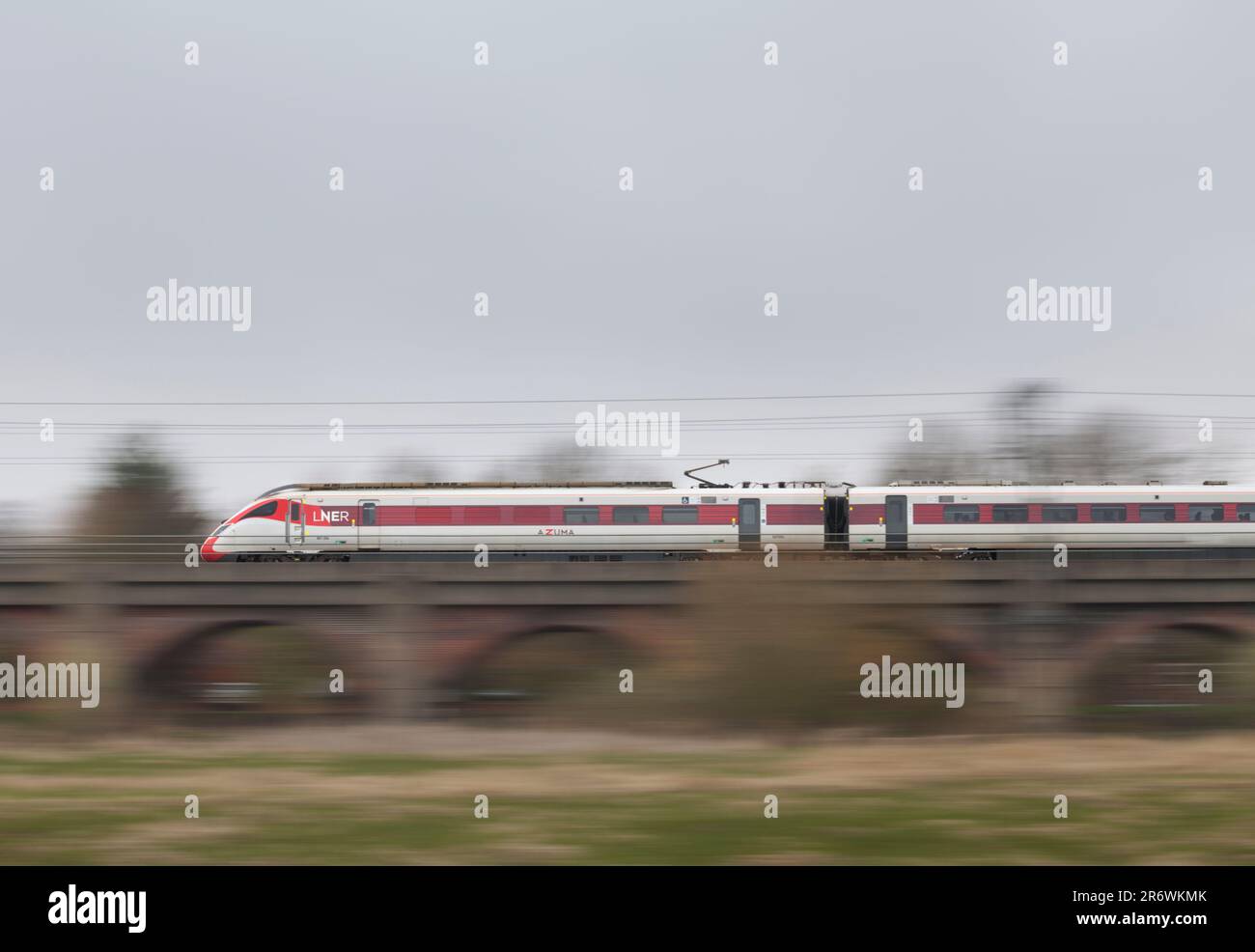 LNER classe 801 treno elettrico Azuma che accelera lungo la linea principale della costa orientale con sfocatura del movimento che attraversa il viadotto di Bawtry Foto Stock