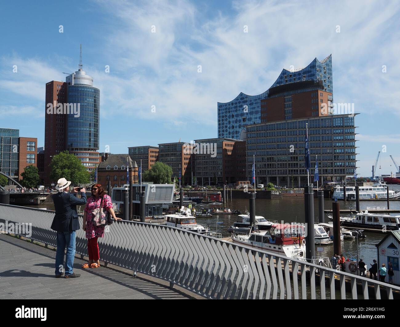 Coppia che si diverti in un viaggio ad Amburgo, in Germania, sulla riva del fiume Elba con il famoso edificio Elbphilharmonie sullo sfondo Foto Stock
