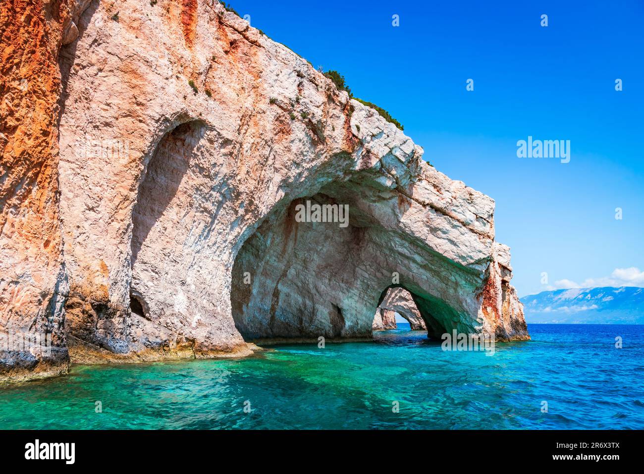Zante, Grecia. Archi rocciosi delle grotte blu da una barca turistica con i turisti in acque blu del Mar Ionio. Grecia vacanze tour vacanza con viaggio Foto Stock