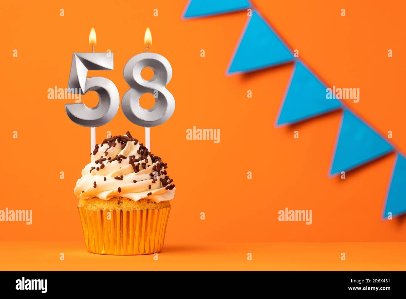 Torta di compleanno con candela numero 58 - sfondo arancione Foto Stock