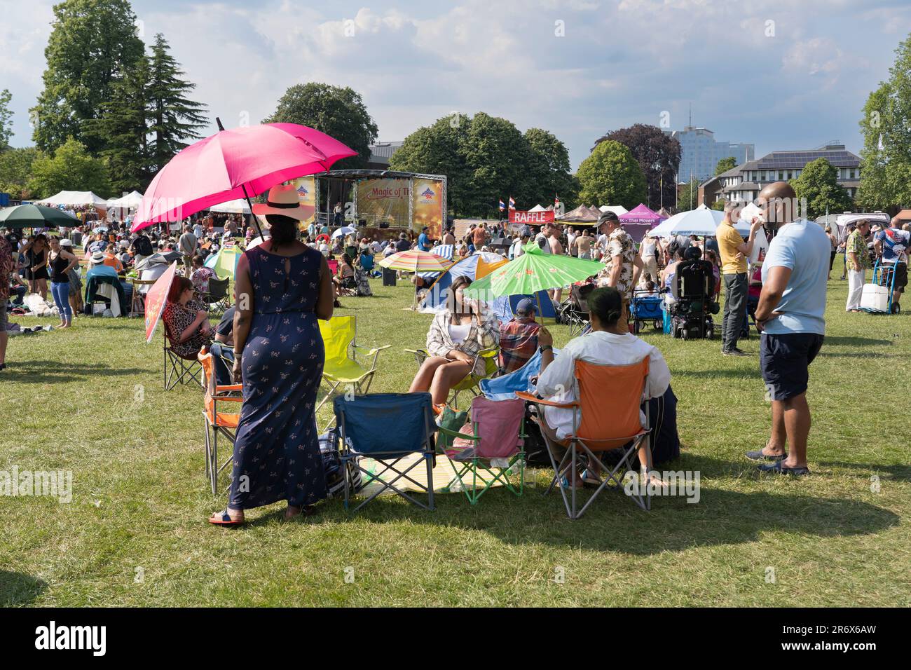 La gente si gode il sole estivo e guarda i cantanti al Magic of Thailand Festival al Basingstoke War Memorial Park. Giugno 10th 2023. Inghilterra Foto Stock