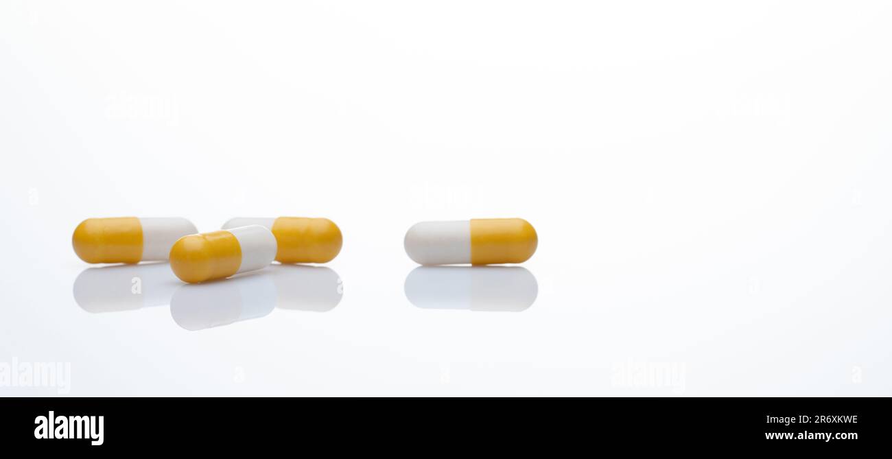 Capsule pills gialle e bianche su sfondo bianco. Farmaci da prescrizione. Industria farmaceutica. Concetto di salute e assistenza medica. Online farmacia web Foto Stock