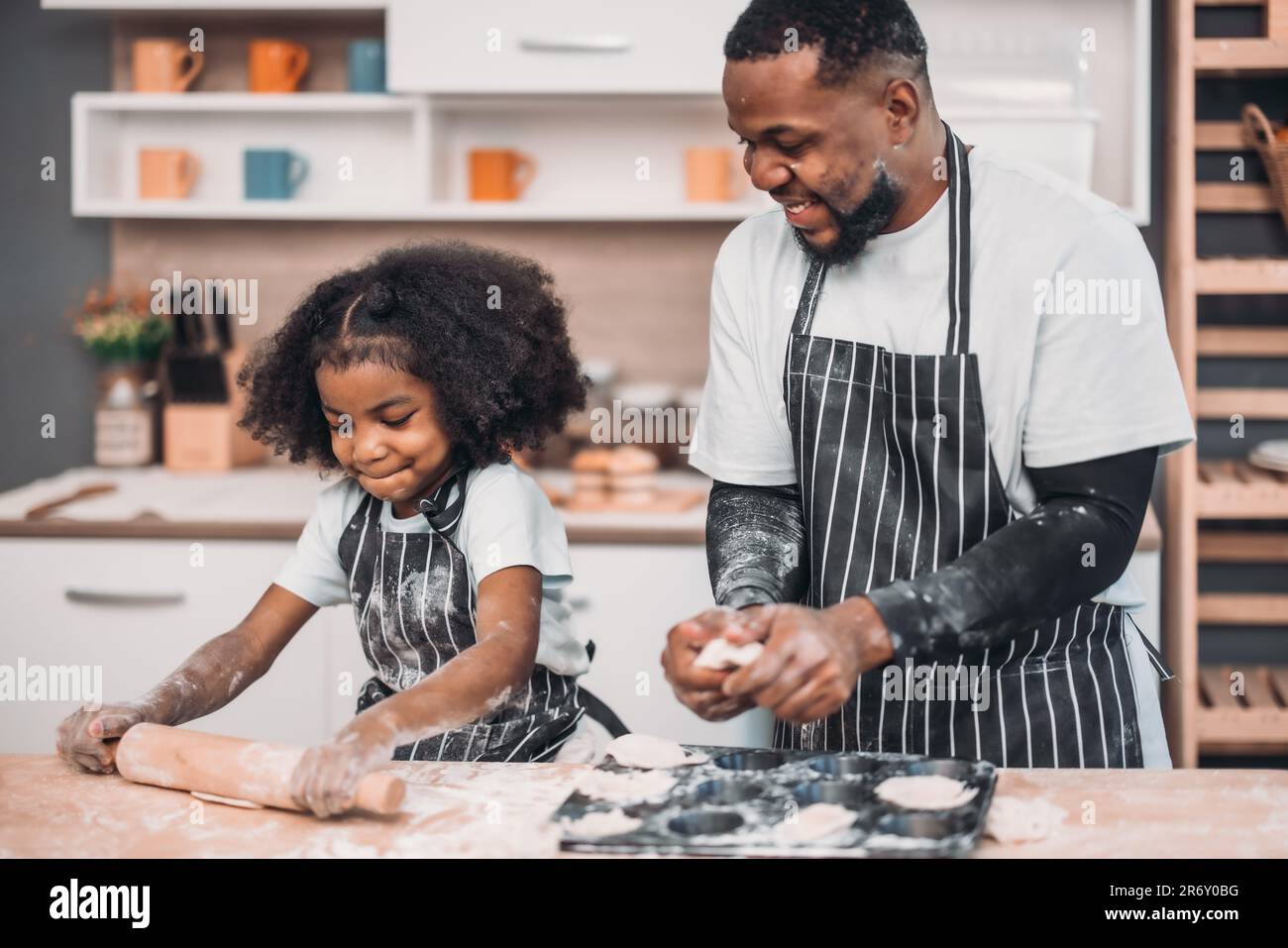 I membri della famiglia cucinano pasta fatta in casa per pizza in modi divertenti e divertenti. Mescolare ingredienti come sale, zucchero, latte, lievito, olio e strofinare, massaggio, pre Foto Stock