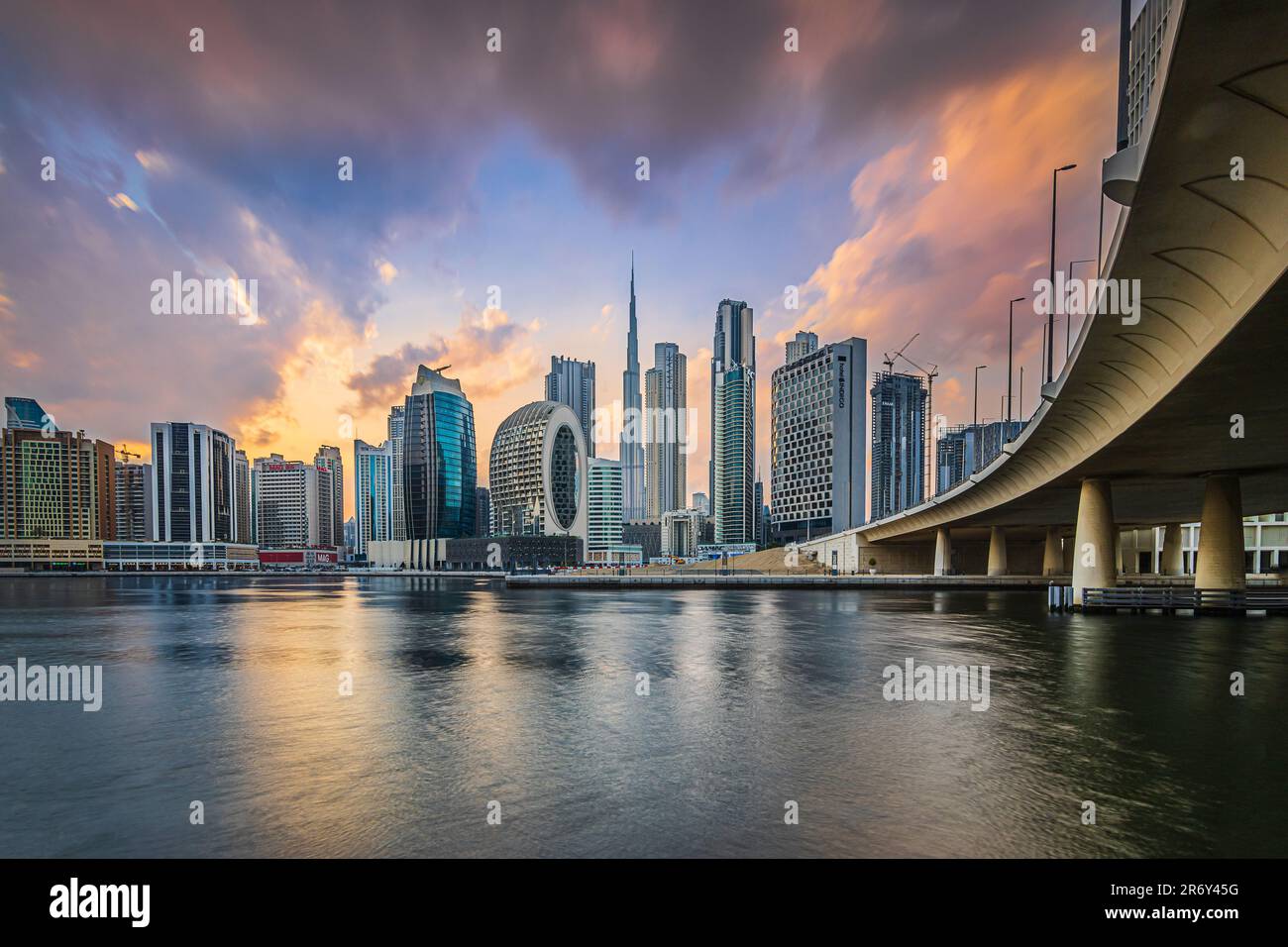 Skyline di Dubai. Atmosfera serale della città araba. Tramonto con grattacieli negli Emirati che si affacciano sul Burj Khalifa. Facciata vetrata di grattacieli. Ponte Foto Stock