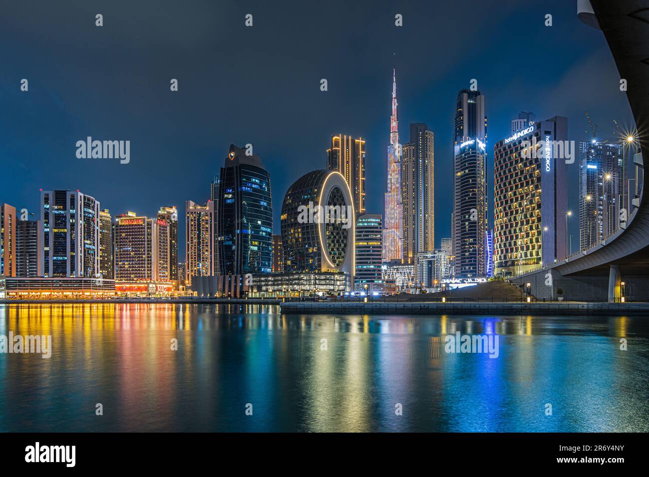 Edifici moderni nel centro della città di Dubai in serata. Grattacieli illuminati nel centro finanziario all'ora blu. Vista dello skyline degli emirati arabi uniti Foto Stock