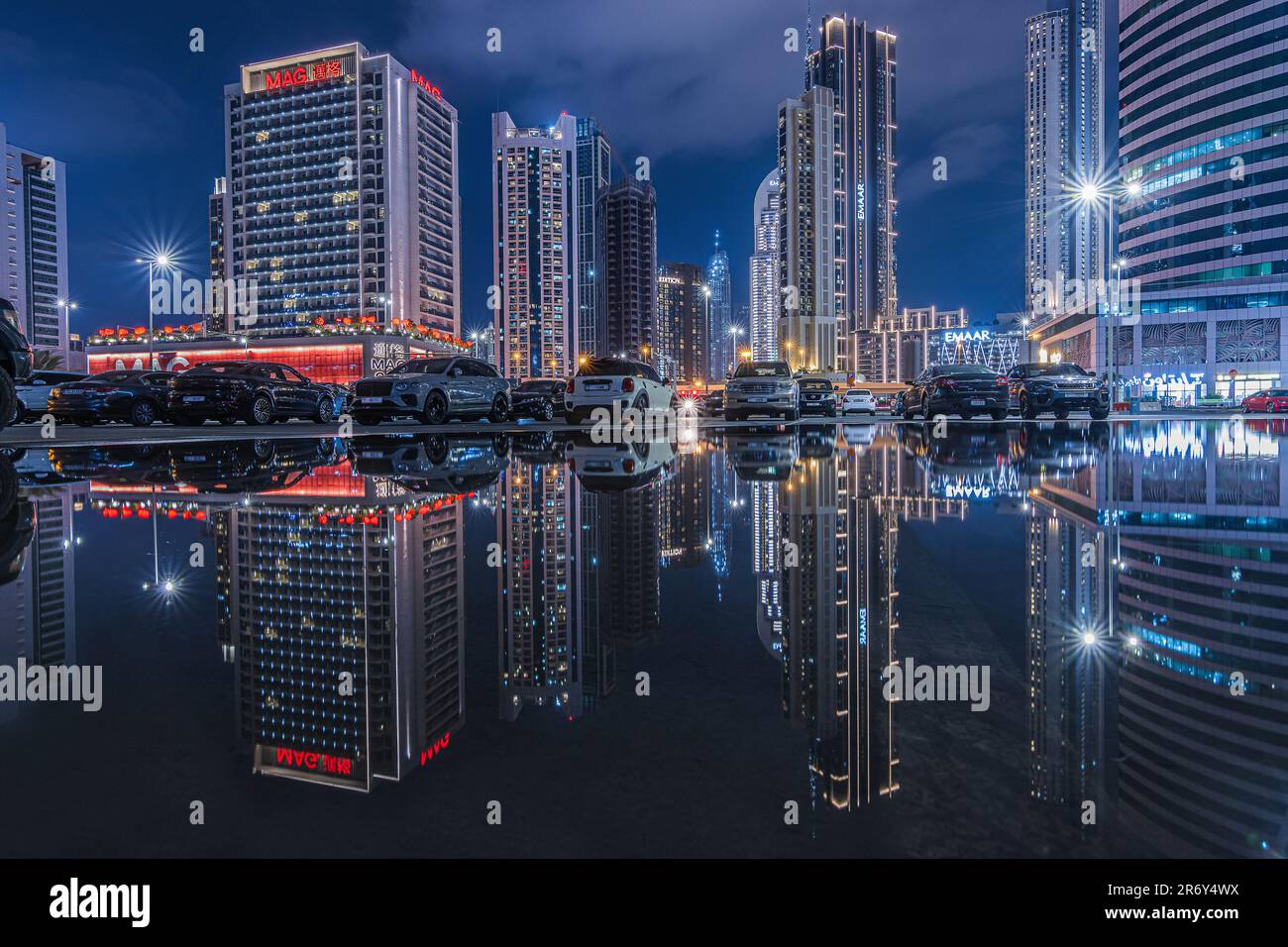 Grattacieli di Dubai di notte. Skyline della città negli Emirati Arabi Uniti all'ora blu. Riflessi dagli edifici commerciali illuminati nel centro commerciale Foto Stock