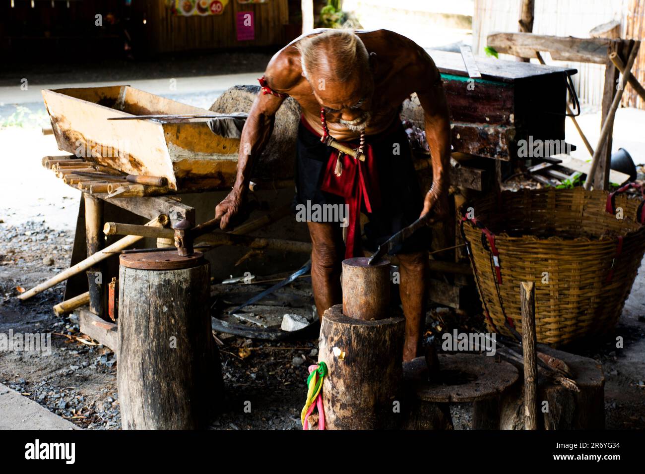 Thai oldman persone fabbro o metalaio che fanno antiche armature di ferro e metallo d'acciaio armi antiche in bottega di fabbro locale di Bang Rachan villaggio a Foto Stock