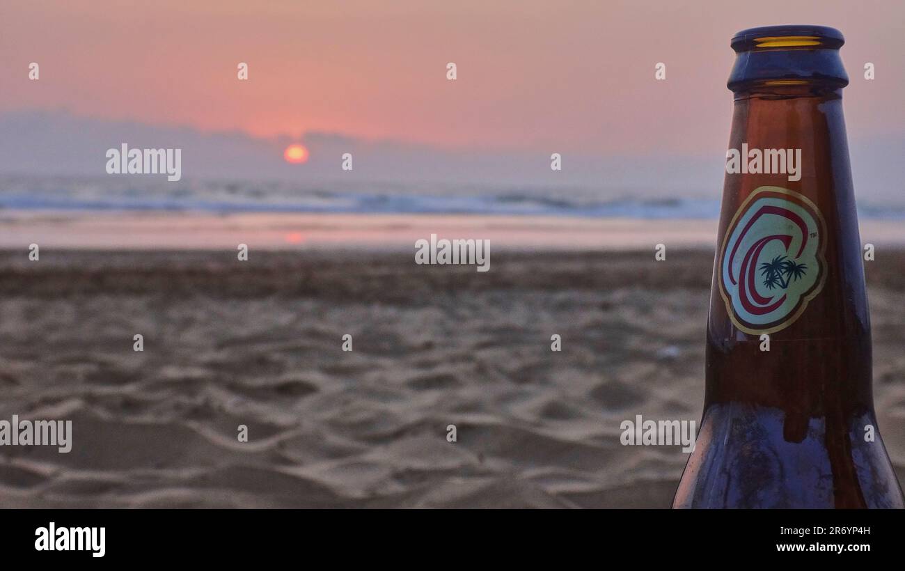 Casablanca, Marocco - 05 19 2016: Bottiglia di birra di Casablanca in piedi su una spiaggia di sabbia di fronte a un romantico tramonto sull'oceano atlantico. Foto Stock