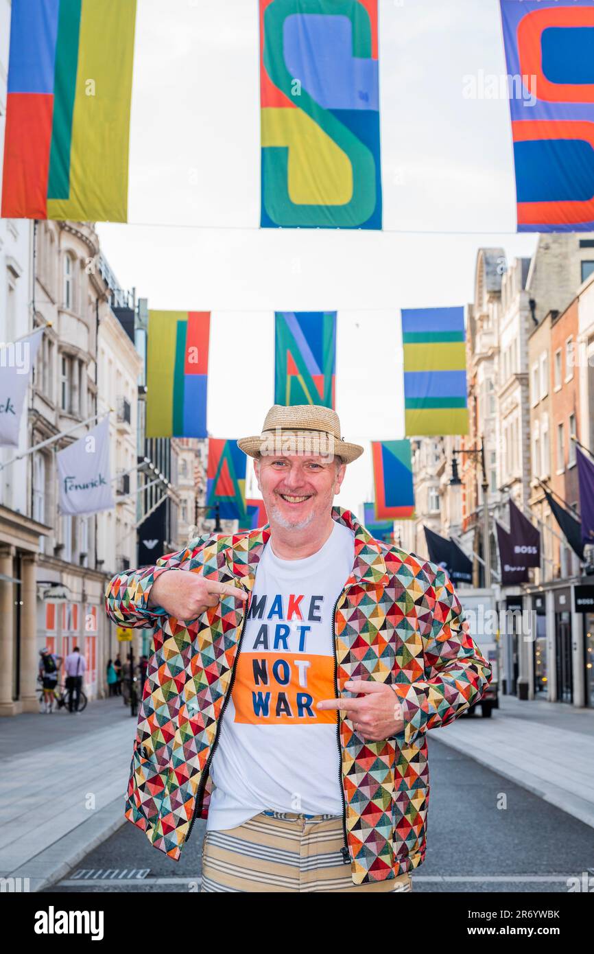 Londra, Regno Unito. 12th giugno, 2023. L'artista britannico Bob & Roberta Smith RA si trova sotto la sua bandiera disegni d'arte dal titolo 'A puzzle 4U' che volano sopra Bond Street, per segnare il lancio di Art in Mayfair per il 2023, in vista della RA Summer Exhibition. Credit: Guy Bell/Alamy Live News Foto Stock