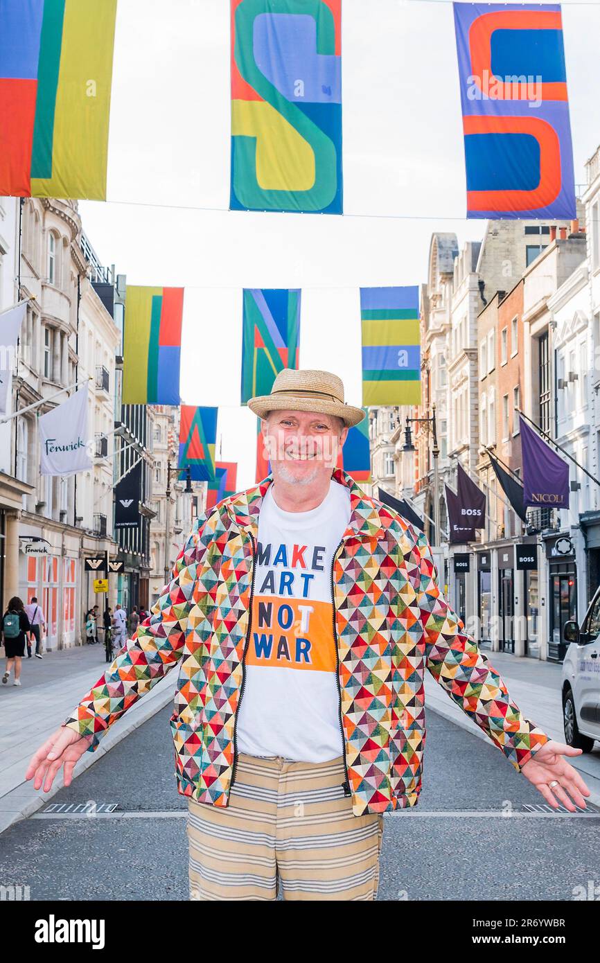 Londra, Regno Unito. 12th giugno, 2023. L'artista britannico Bob & Roberta Smith RA si trova sotto la sua bandiera disegni d'arte dal titolo 'A puzzle 4U' che volano sopra Bond Street, per segnare il lancio di Art in Mayfair per il 2023, in vista della RA Summer Exhibition. Credit: Guy Bell/Alamy Live News Foto Stock