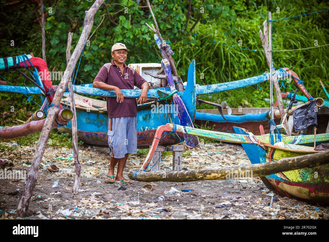 Uomo pescatore vicino alla tradizionale barca da pesca nell'isola di Java, Indonesia. Foto Stock