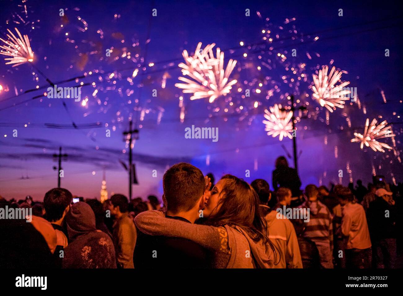 Giovane coppia Kissing sotto i fuochi d'artificio Foto Stock