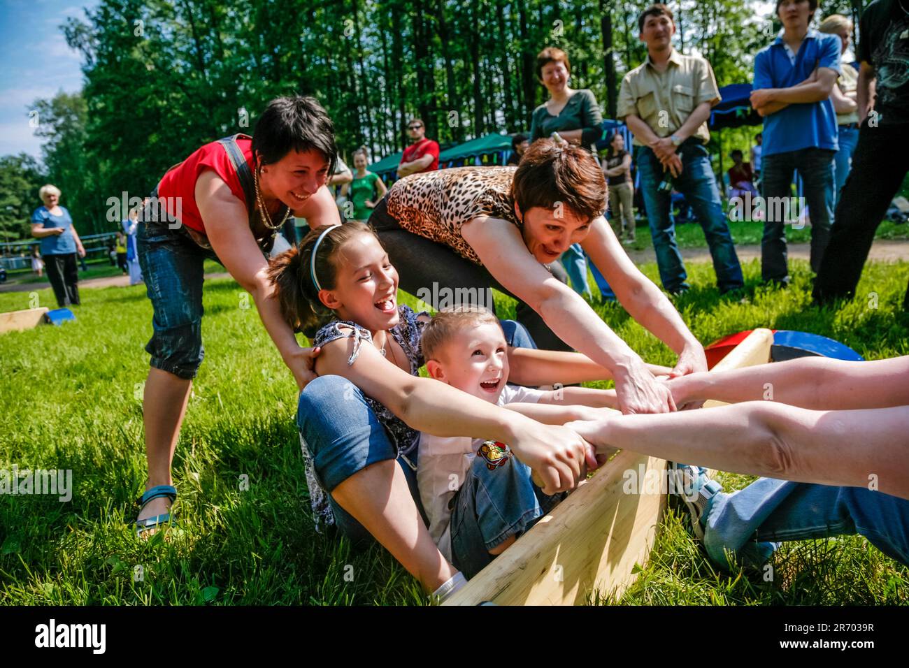 La famiglia si diverti a giocare a Mas-wresling al City Park Foto Stock