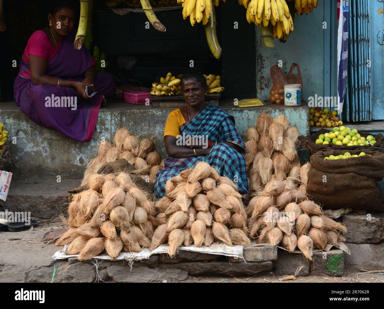 Noci di cocco secche e banane vendute in un negozio al mercato di Madurai, Tamil Nadu, India. Foto Stock