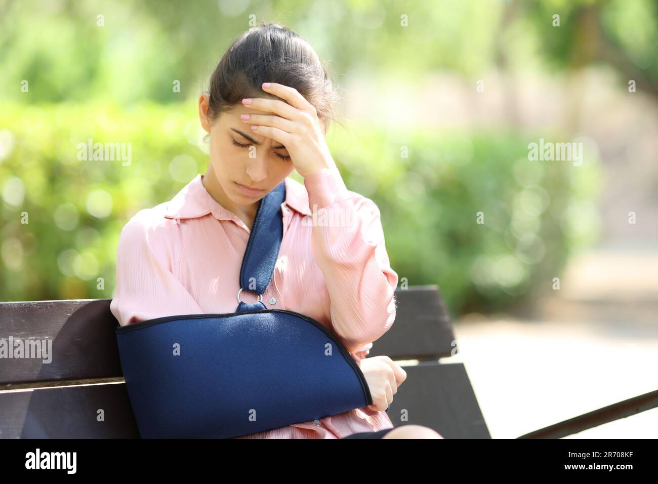 Preoccupata donna convalescente seduta su una panchina che si lamenta in un parco Foto Stock