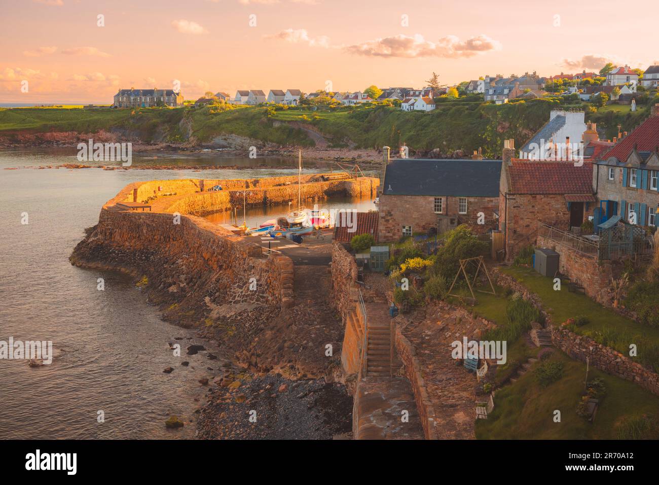 Vista panoramica e pittoresca del tramonto sull'affascinante villaggio costiero di pescatori di Crail e sul suo porto a East Neuk, Fife, Scozia, Regno Unito. Foto Stock