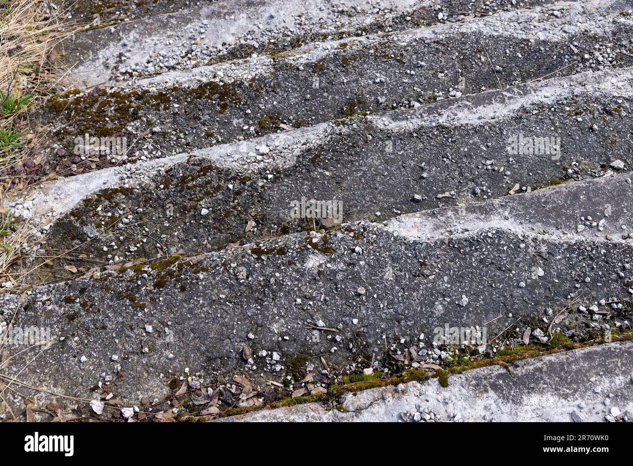 una vecchia scala in cemento rovinato e pietra nel parco, i dettagli delle vecchie parti della scala di cui sono danneggiati o distrutti Foto Stock