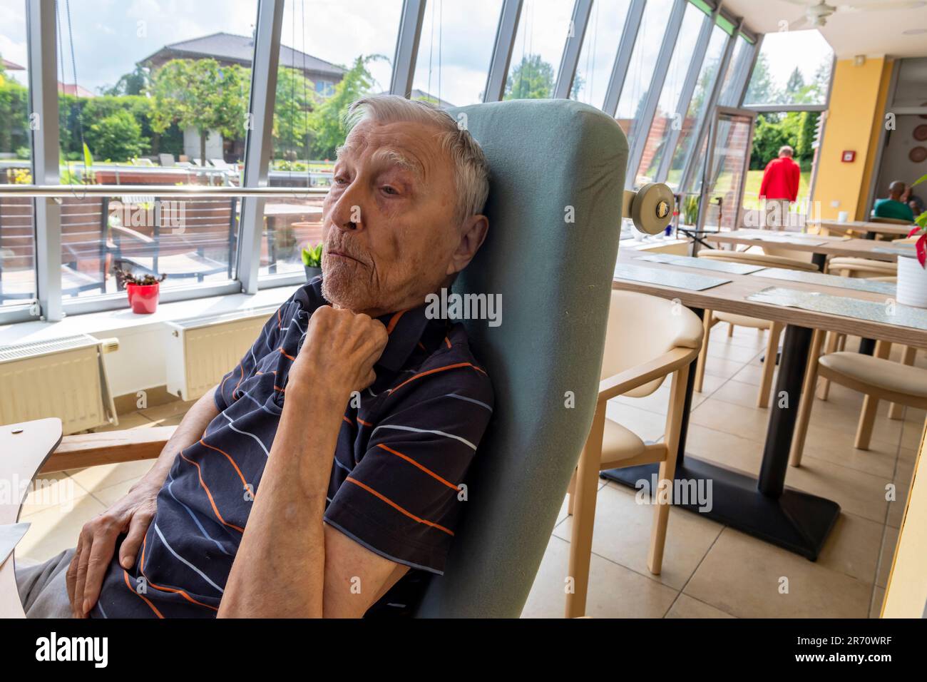 pensionato di vecchiaia seduto al tavolo di riposo a casa Foto Stock