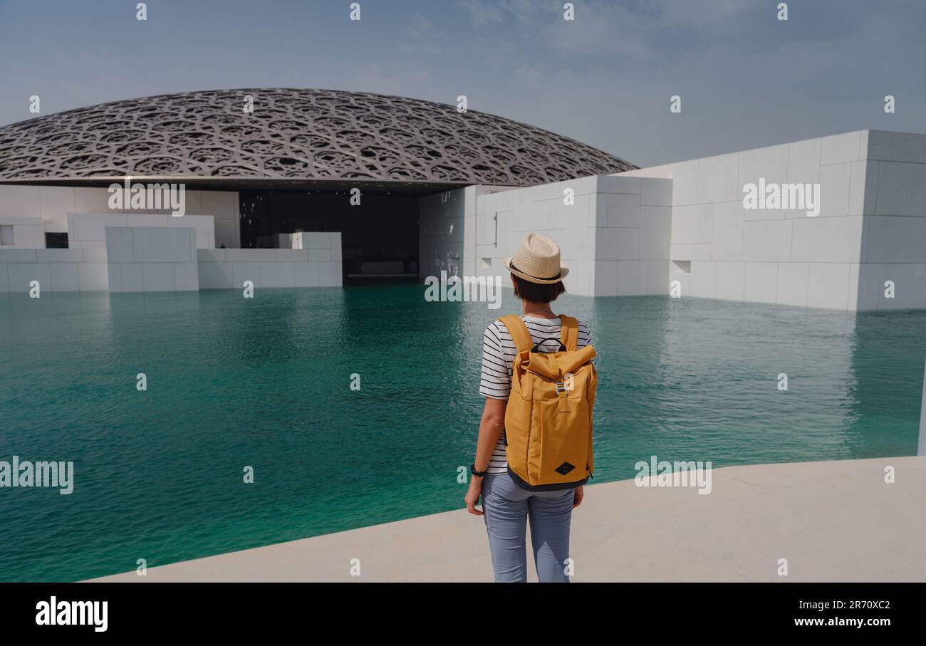Abu Dhabi, Emirati Arabi Uniti - 21 marzo 2023 : viaggiatore femminile vicino al museo del Louvre ad Abu Dhabi, Emirati Arabi Uniti. Il Louvre è un nuovo museo negli Emirati Arabi Uniti aperto il 8th 2017 novembre Foto Stock