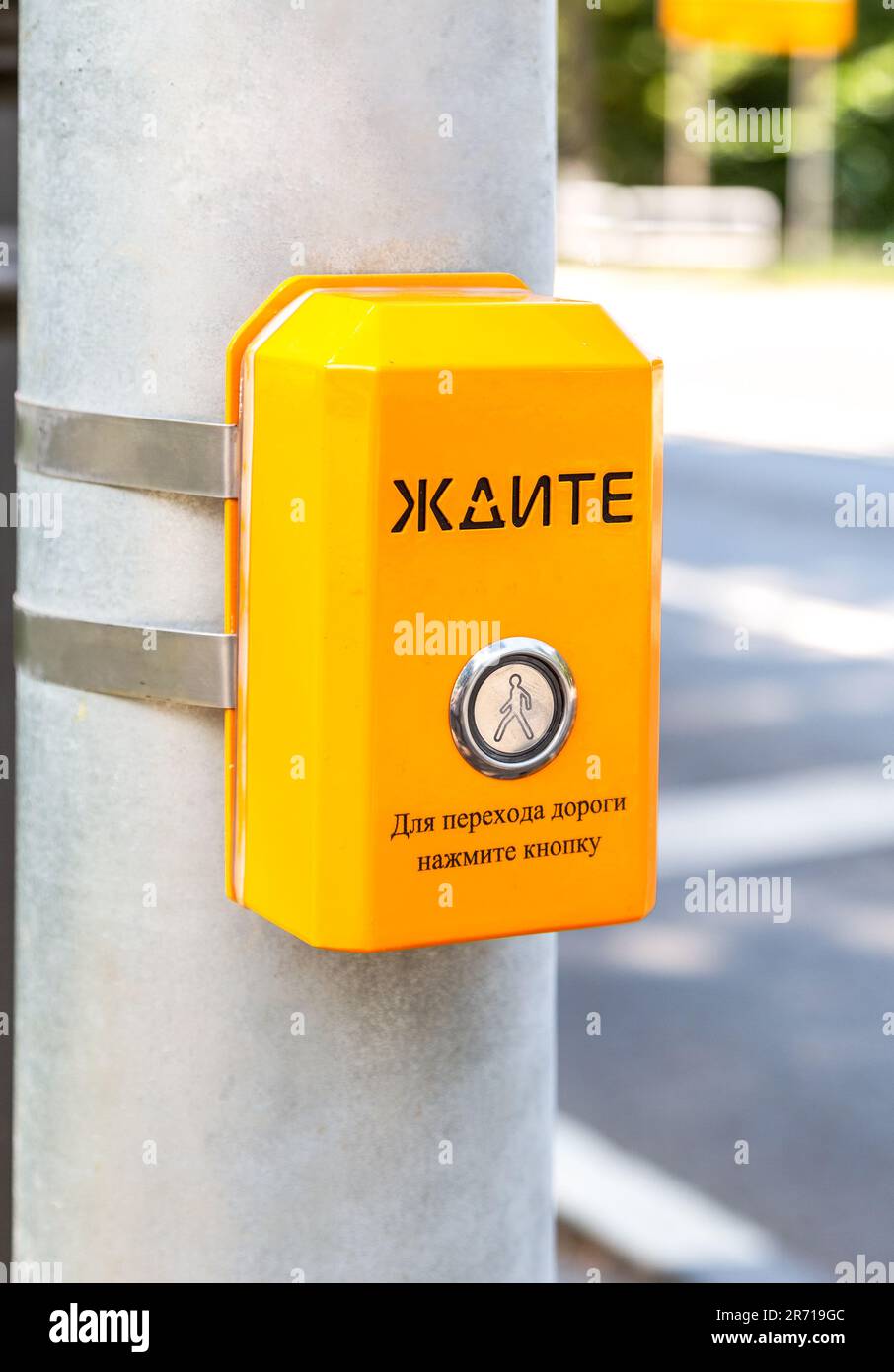 Segnale di attesa pedoni, utilizzato per aiutare le persone a attraversare la strada in modo sicuro. Testo in russo: ATTENDERE. Per attraversare la strada - premere il pulsante Foto Stock