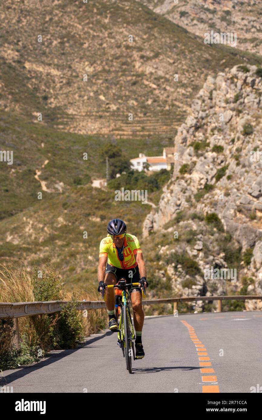 Ciclista in salita in un paesaggio selvaggio Foto Stock